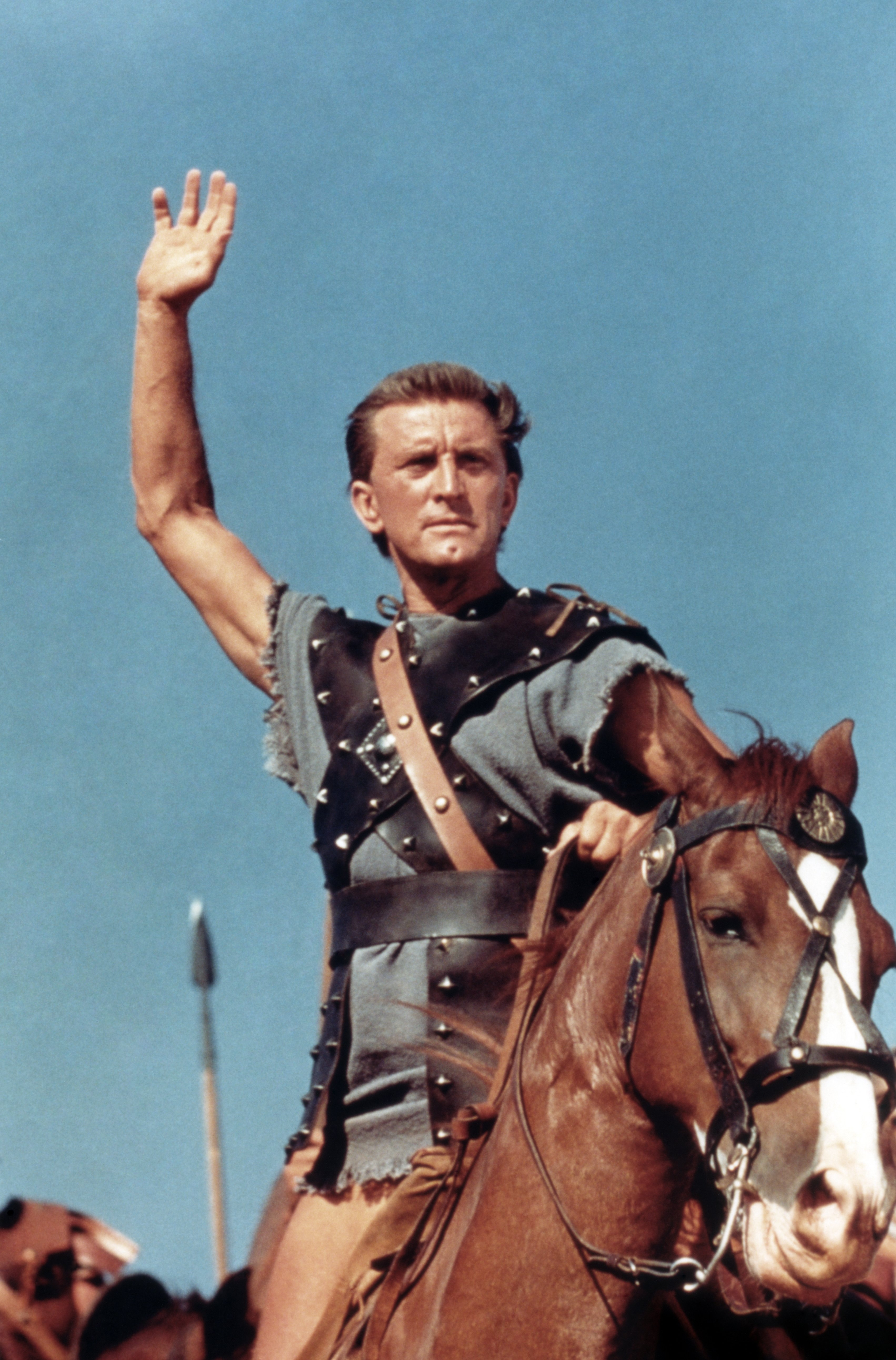 Kirk Douglas dans le film d'action "Spartacus" de 1960, photographié sur un cheval, la main levée en l'air. / Source : Getty Images