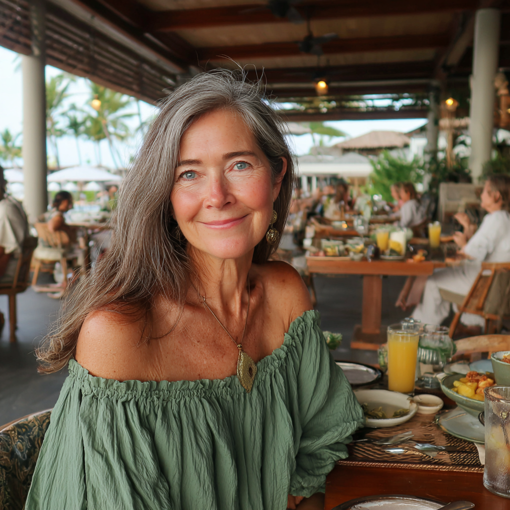 Une femme âgée souriante assise à une table | Source : Midjourney