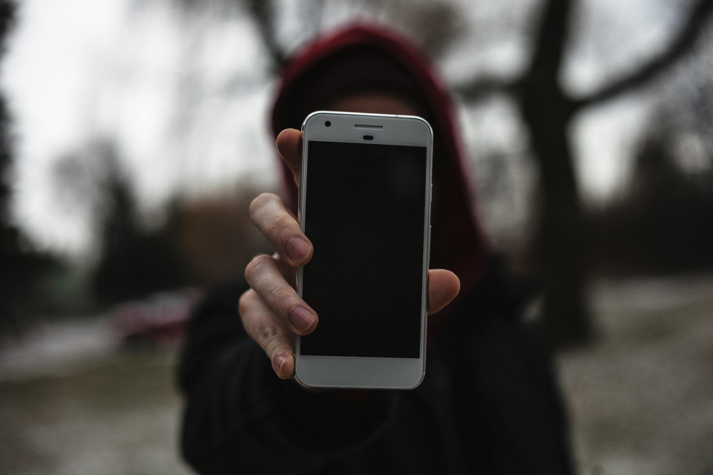 Une femme qui tend un téléphone | Source : Unsplash