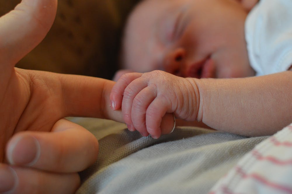 Bébé tenant le doigt de sa mère | Photo : Pexels