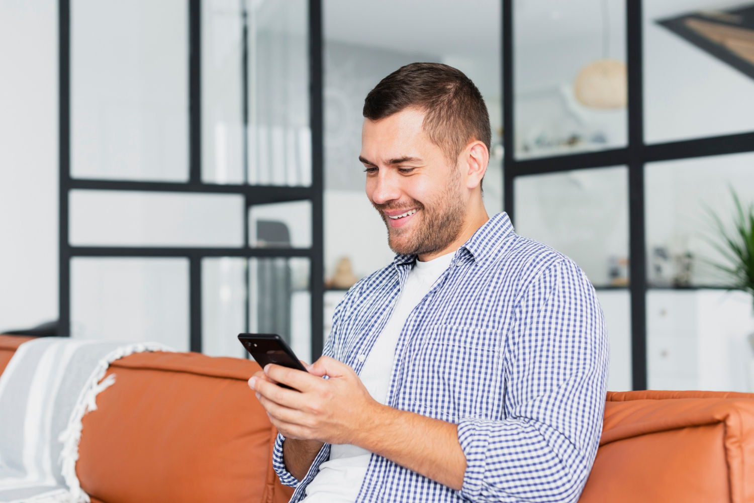Un homme qui regarde son téléphone et sourit | Source : Freepik