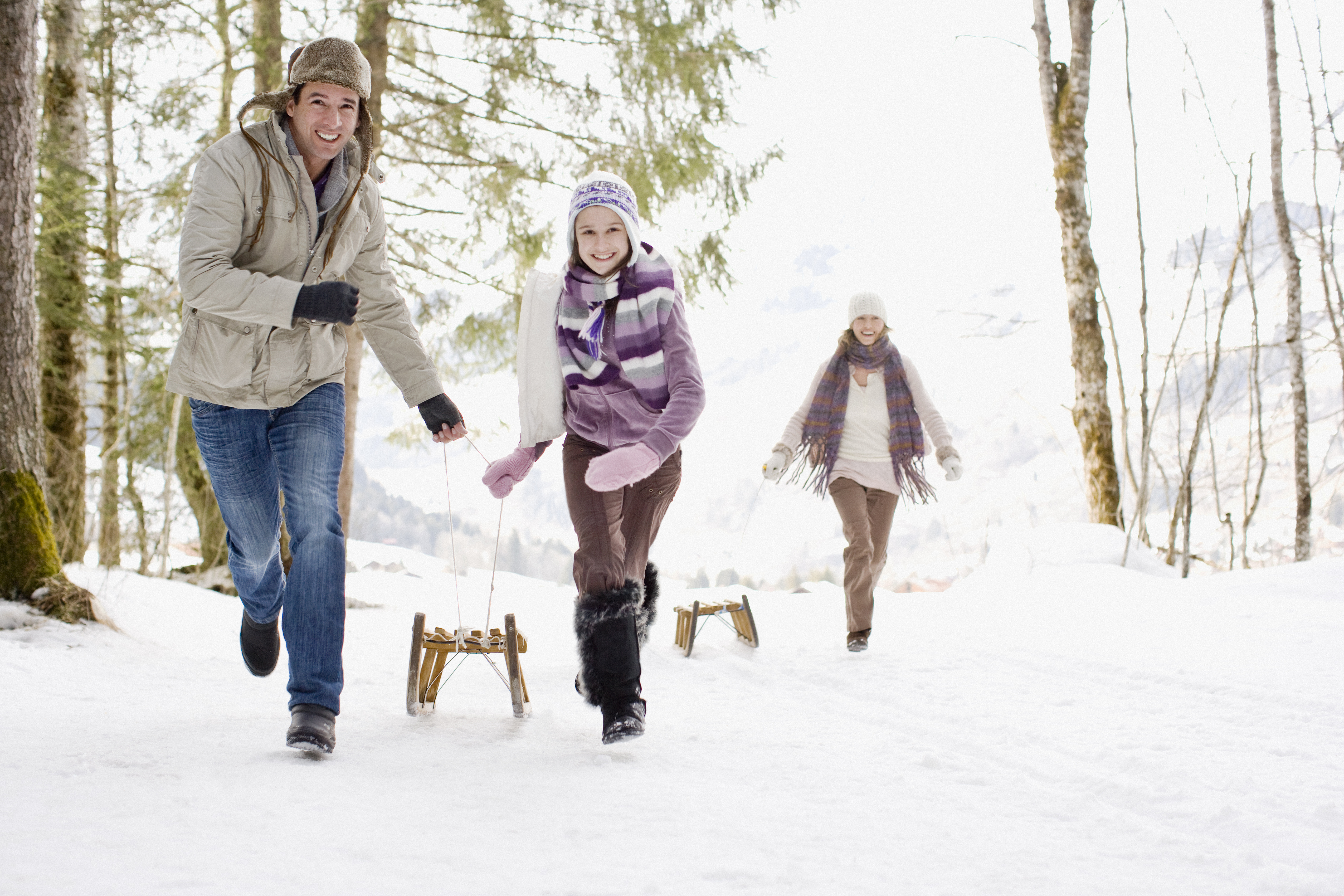 Famille tirant des traîneaux dans la neige | Source : Getty Images