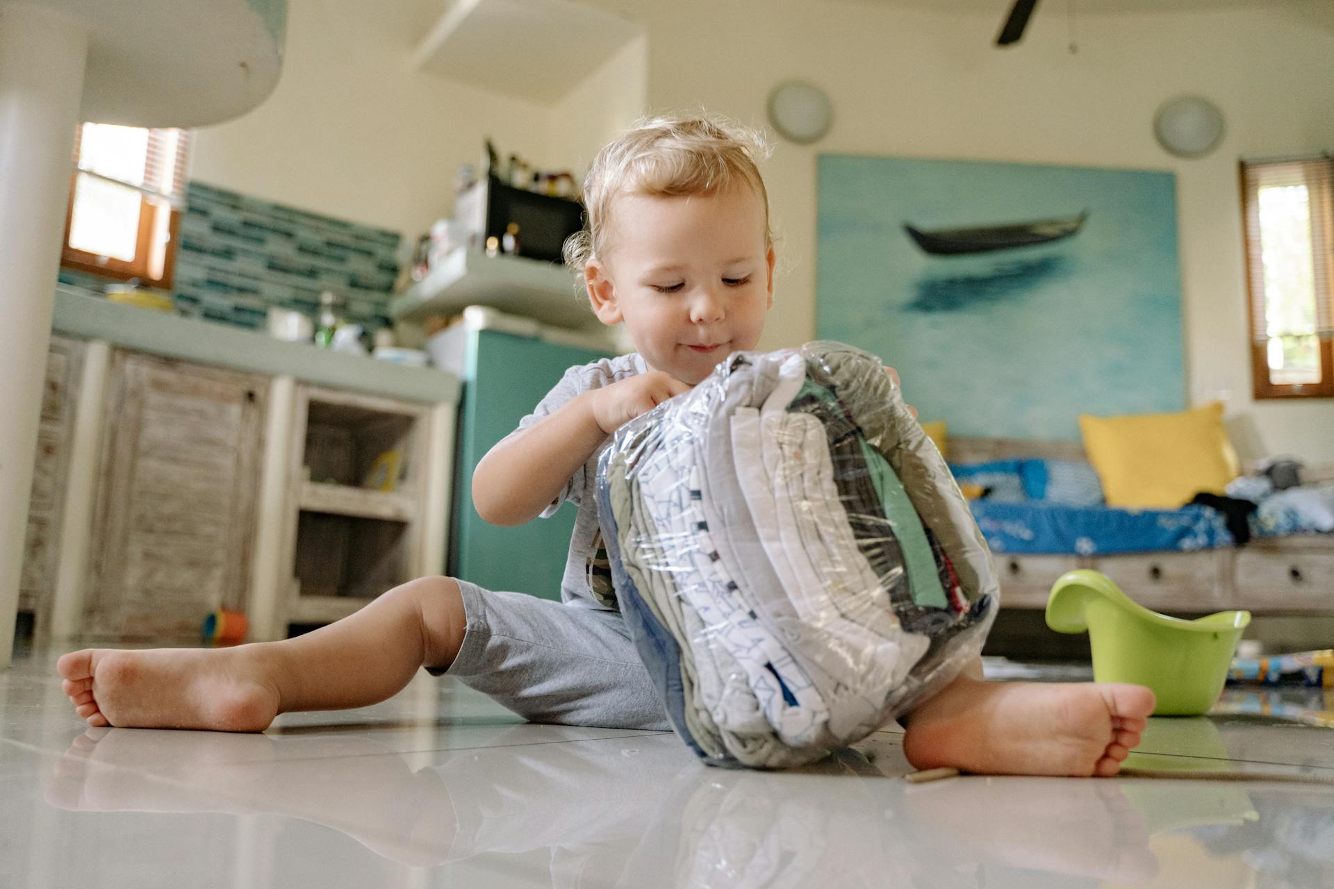 Un enfant qui joue avec des vêtements dans un sac en plastique | Source : Pexels