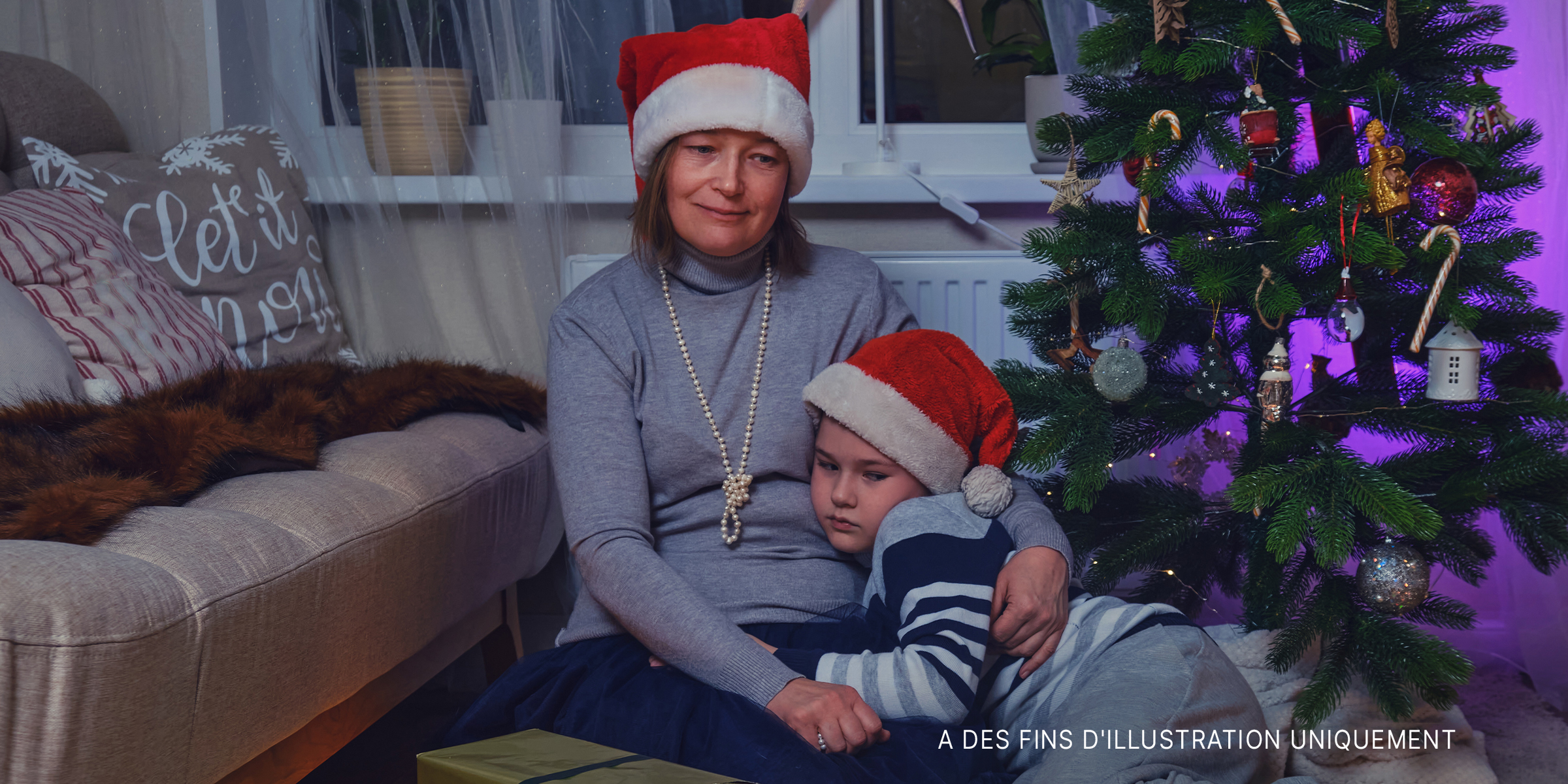 Mère et fils tristes assis près du sapin de Noël | Source : Getty Images