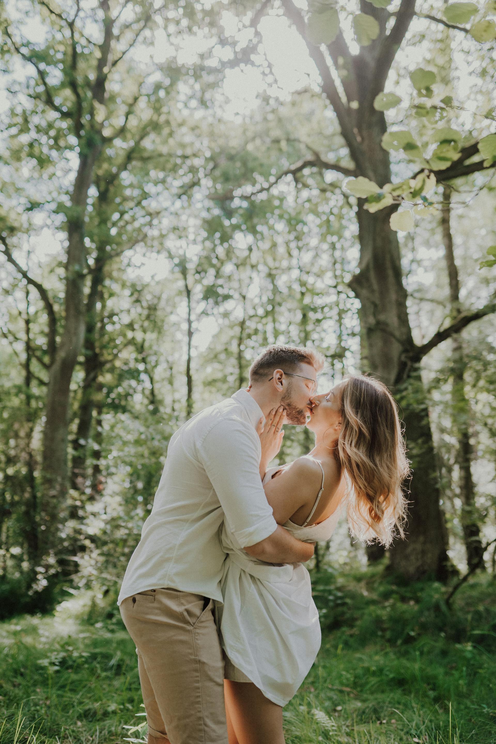 Un jeune couple s'embrassant dans une forêt | Source : Pexels