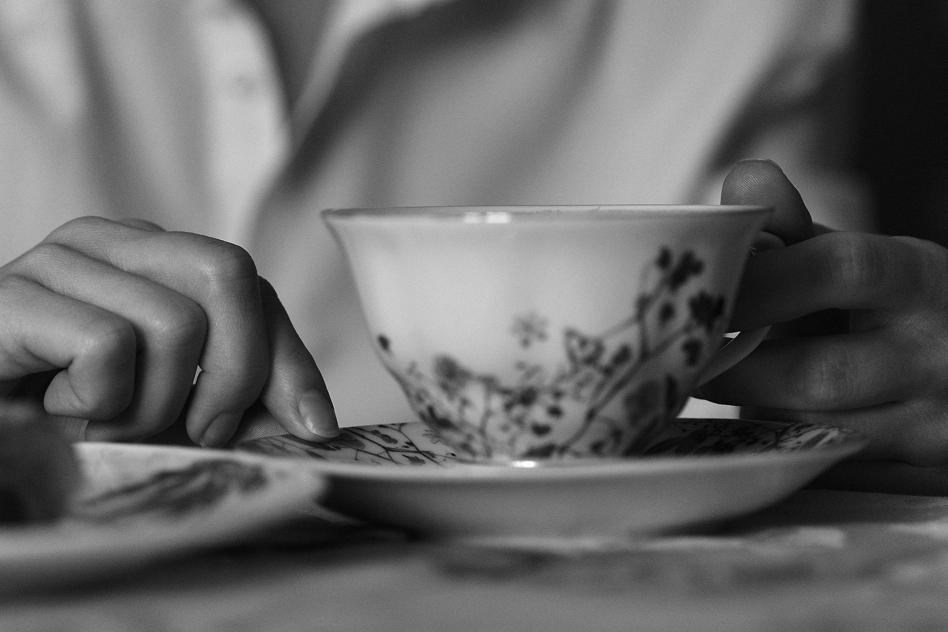Une photo en niveaux de gris d'une femme tenant une tasse de thé | Source : Pexels
