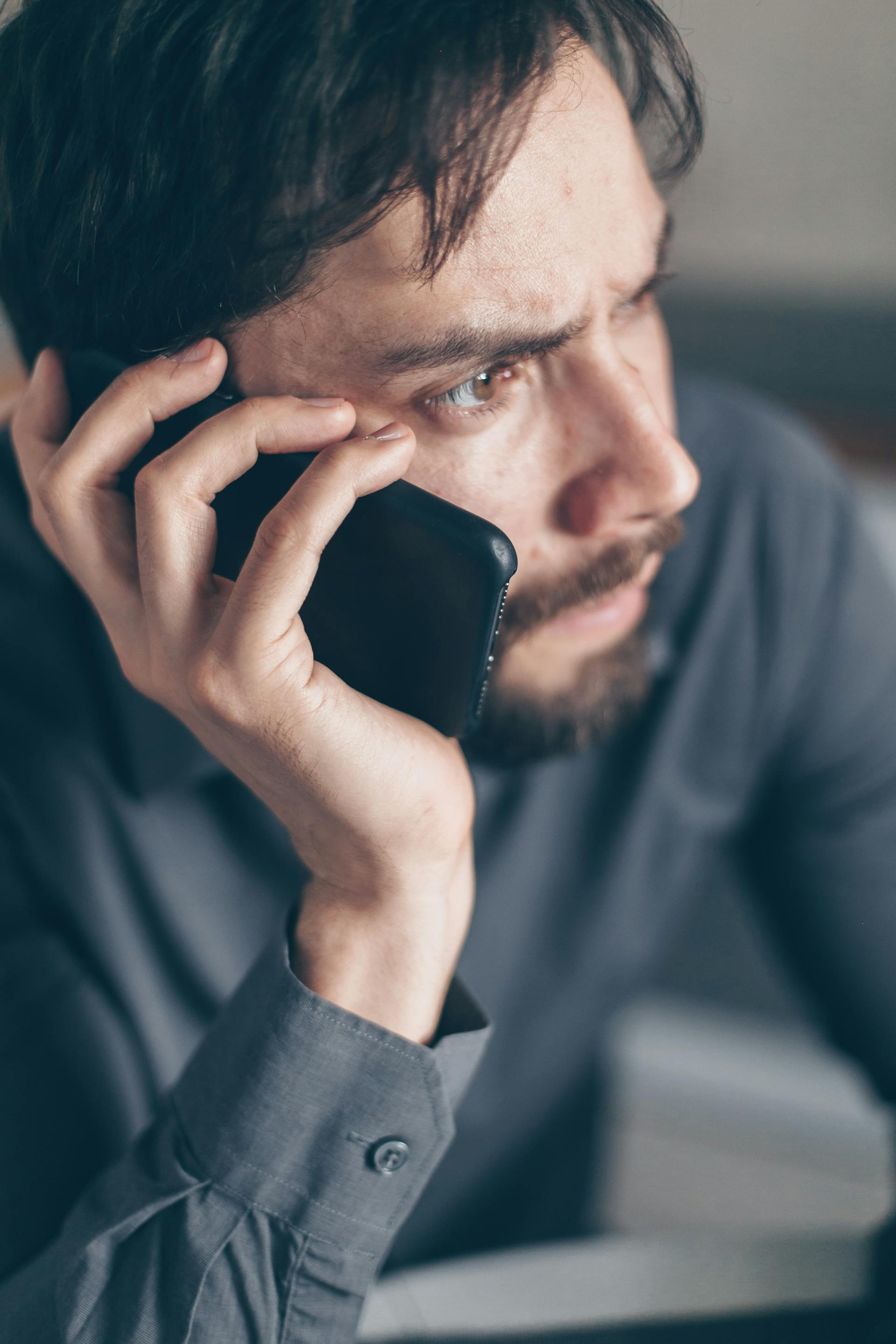 Un homme anxieux tenant un smartphone | Source : Pexels