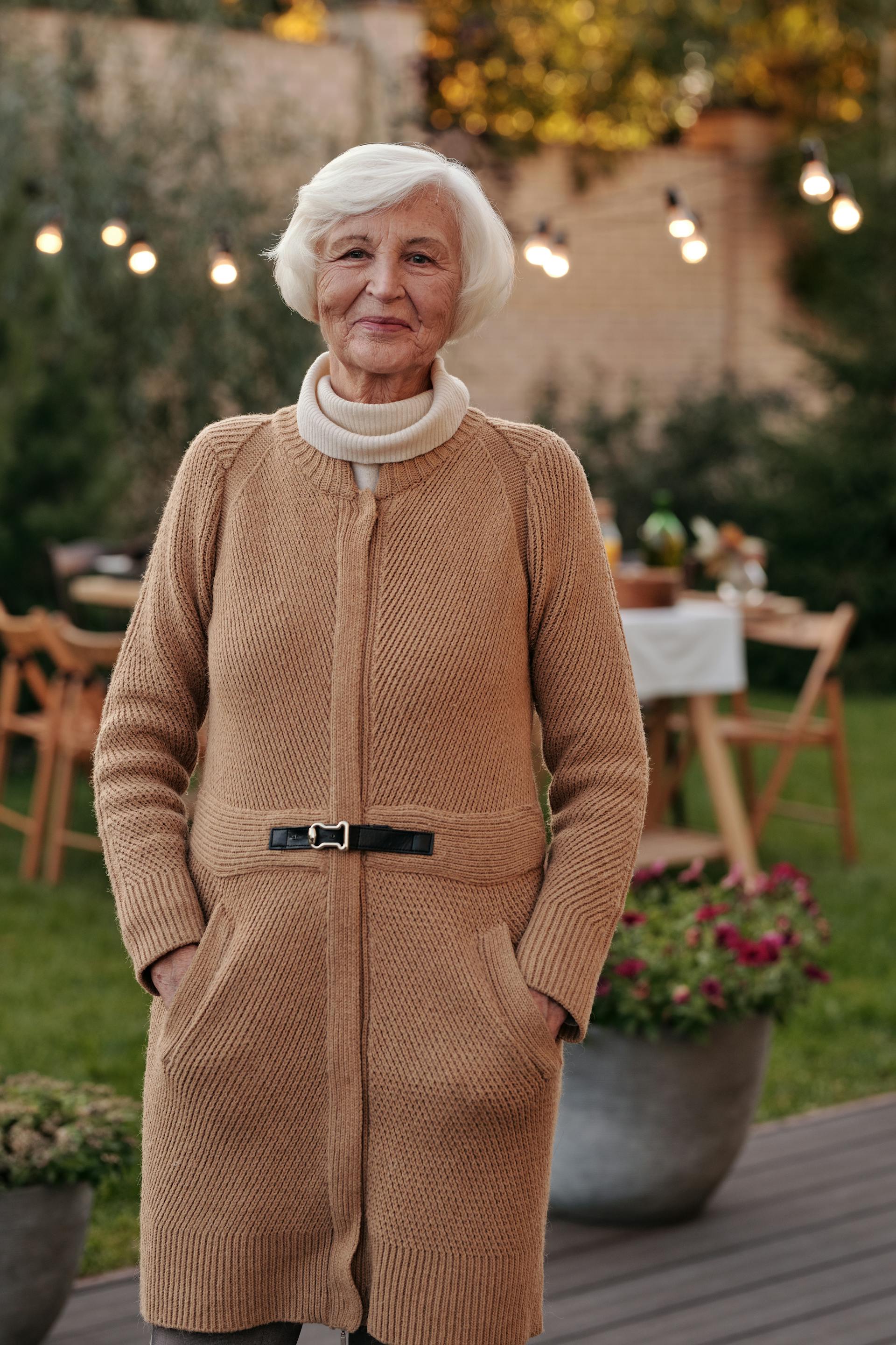 Une vieille femme souriante portant un manteau | Source : Pexels