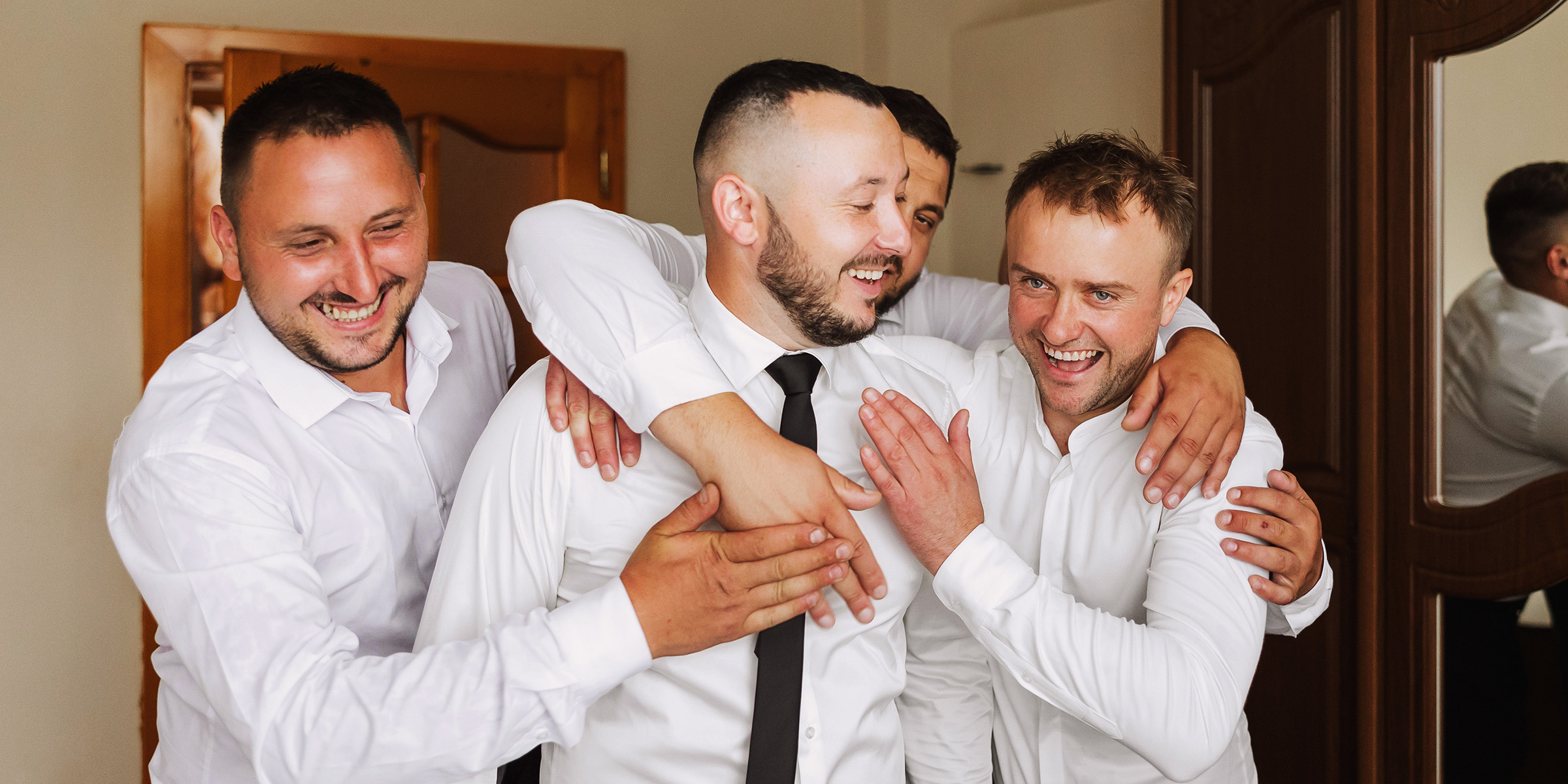 Un marié qui rit avec ses garçons d'honneur | Source : Shutterstock