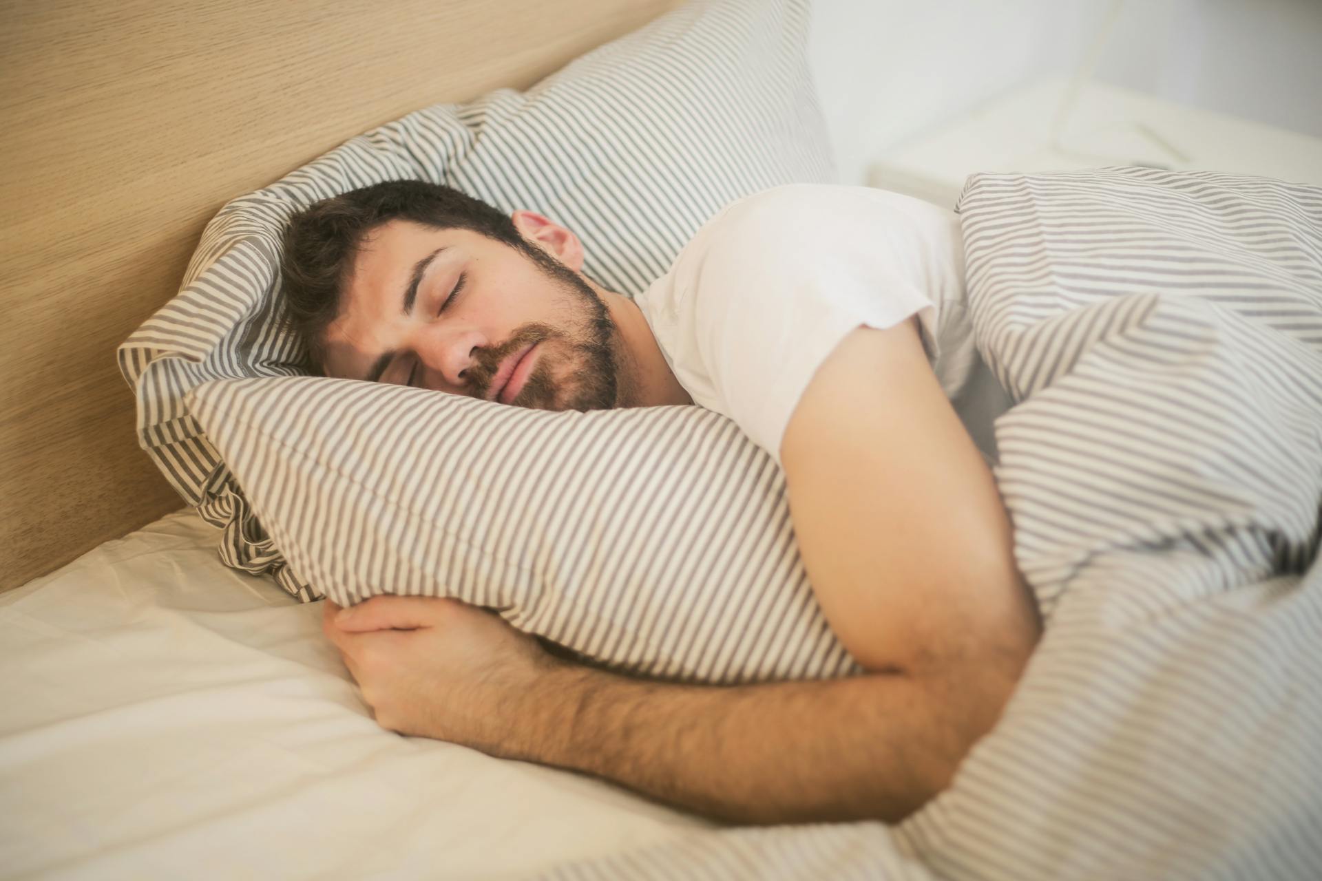 Un homme dormant dans un lit | Source : Pexels