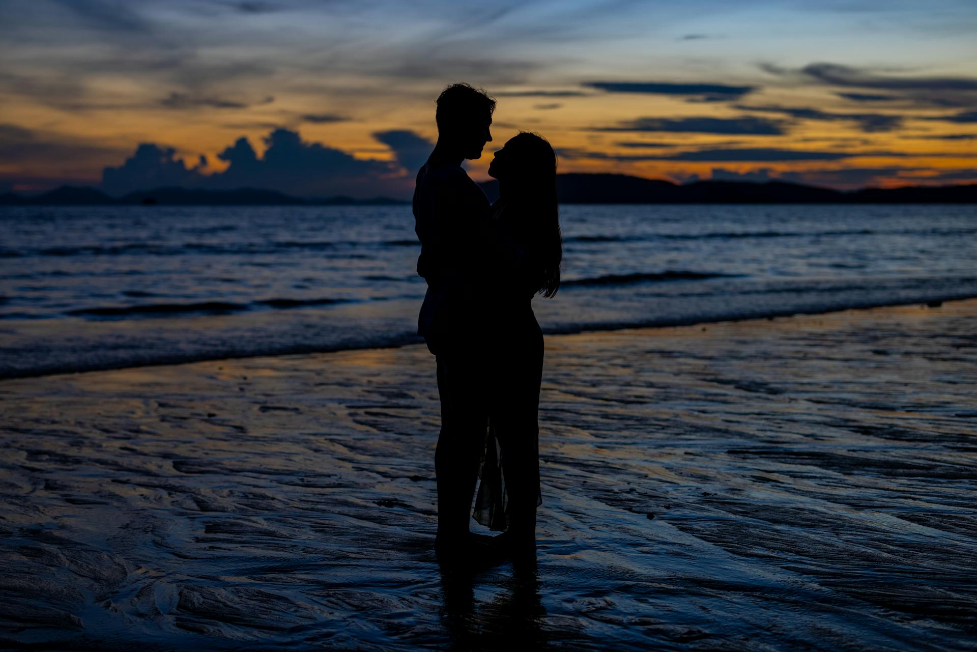 Silhouette of a loving couple hugging on a seaside at sunset | Source: Pexels