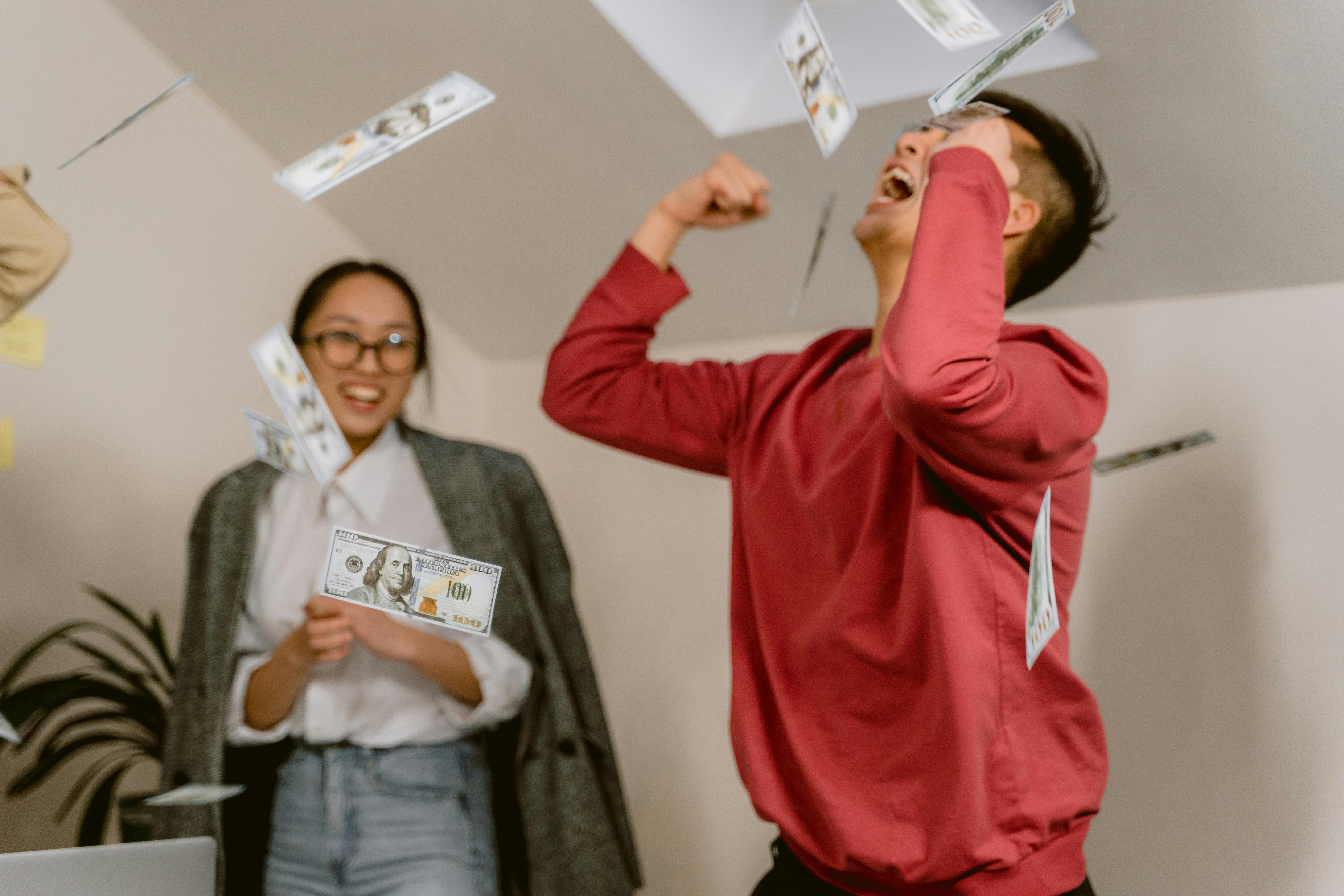 Une femme regardant un homme faire la fête en jetant de l'argent en l'air | Source : Pexels