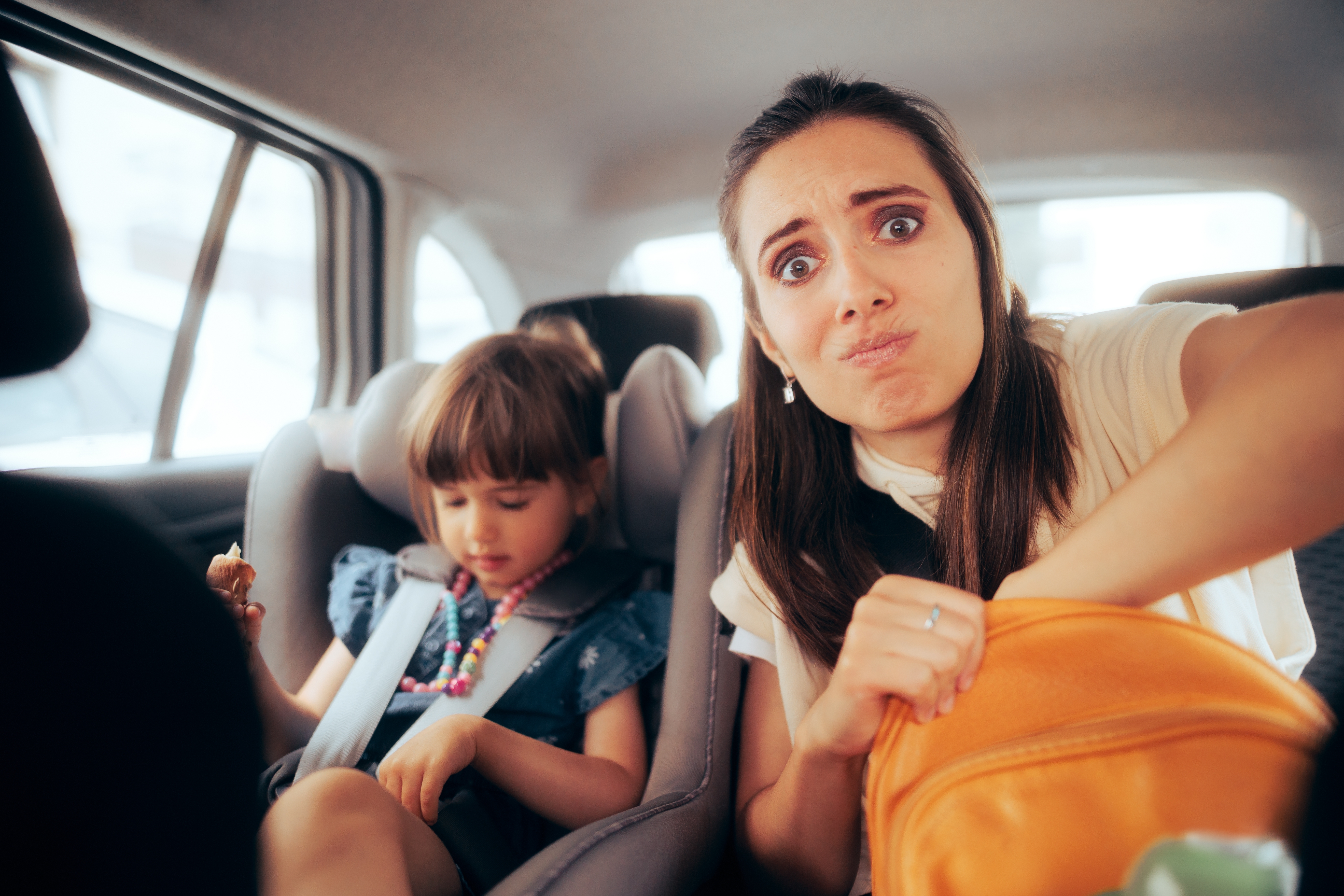 Uma mulher estressada sentada em um carro com uma menina | Fonte: Shutterstock