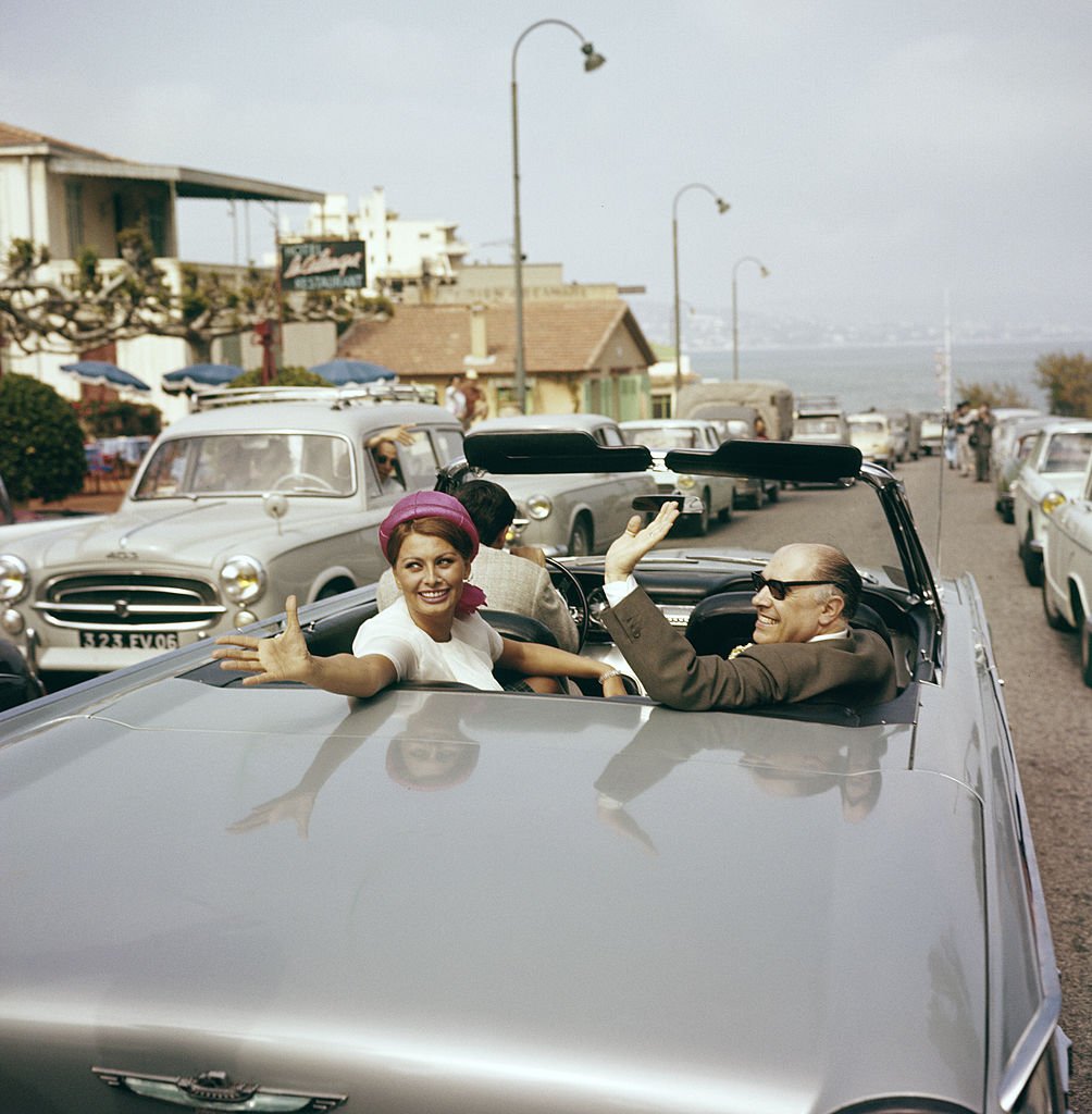 Sophia Loren, sept fois récompensée par un Golden Globe, dans une voiture avec son mari, Carlo Ponti, saluant la foule en 1960. | Photo : Getty Images