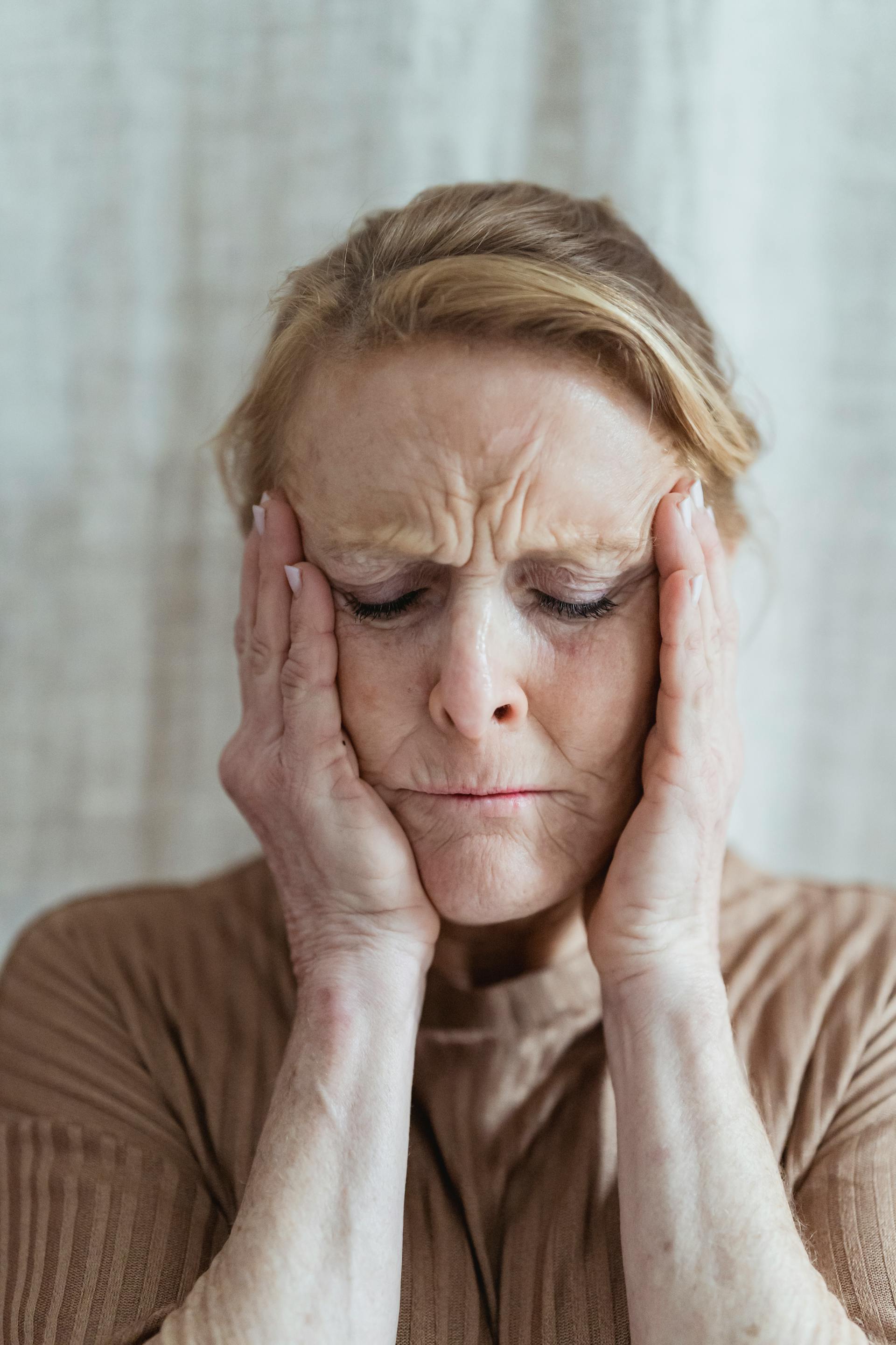 Une femme âgée stressée se tenant le visage | Source : Pexels