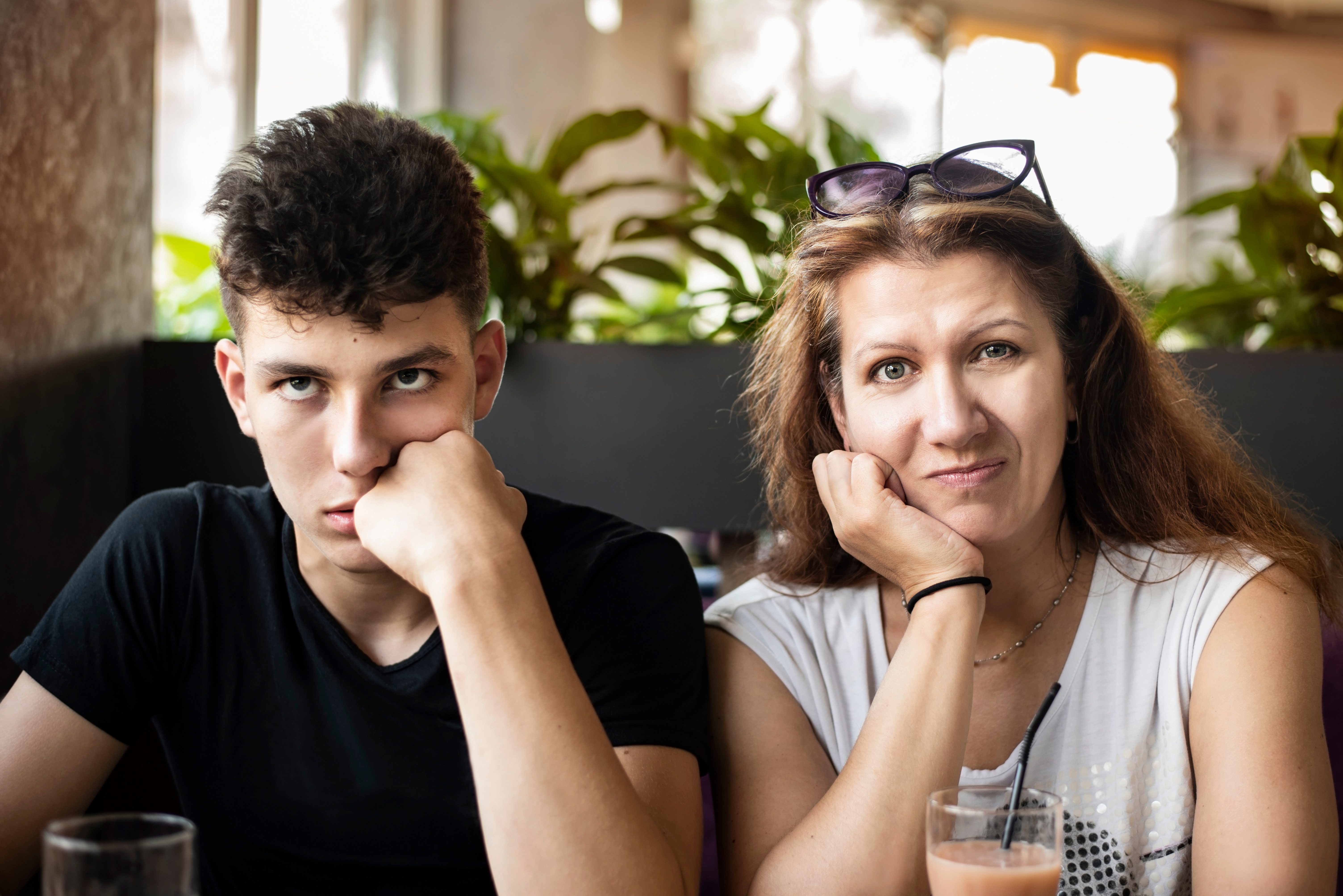 Adolescent frustré assis à côté d'une femme à l'expression confuse | Source : Shutterstock