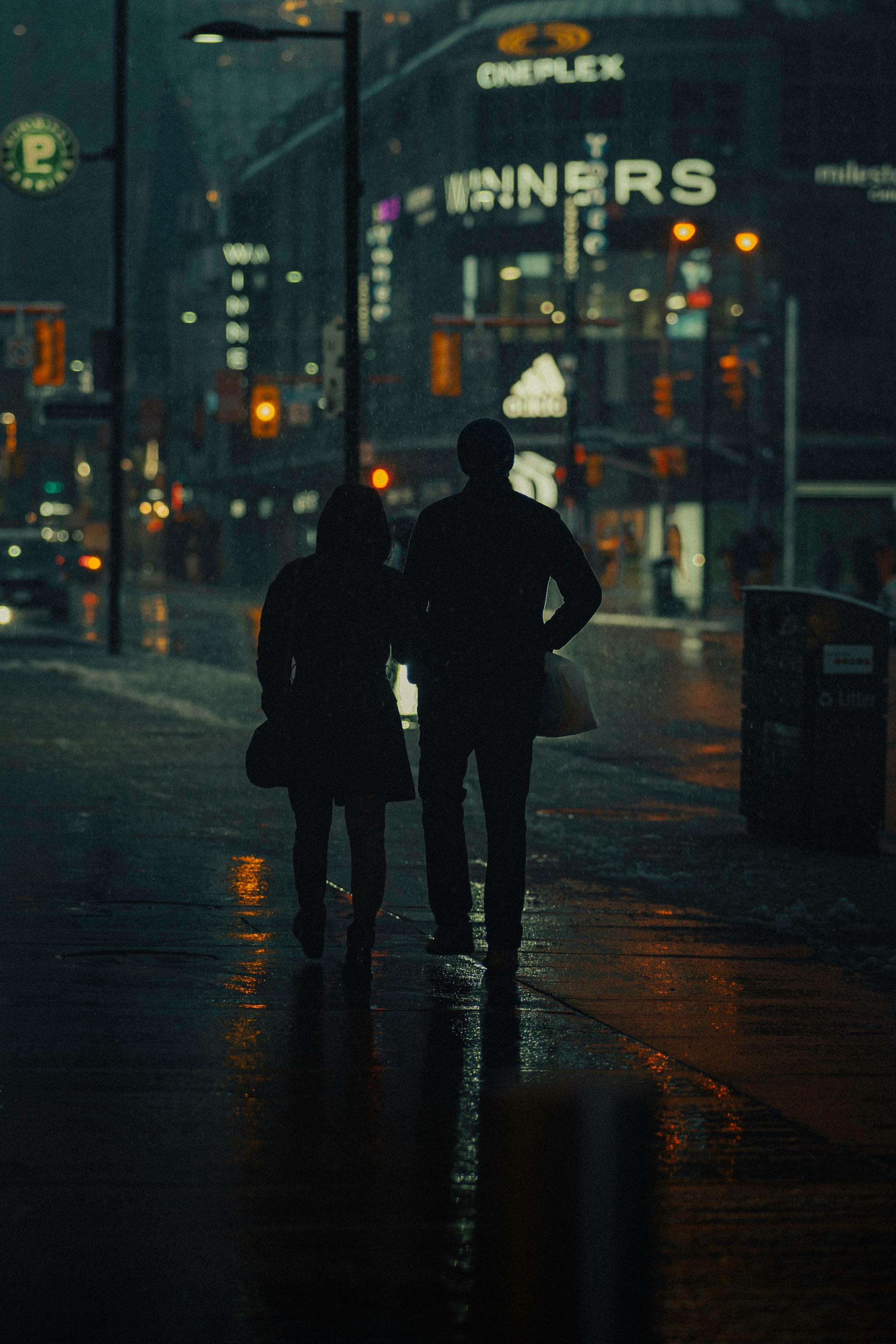 Silhouette d'un couple marchant dans la rue la nuit | Source : Pexels