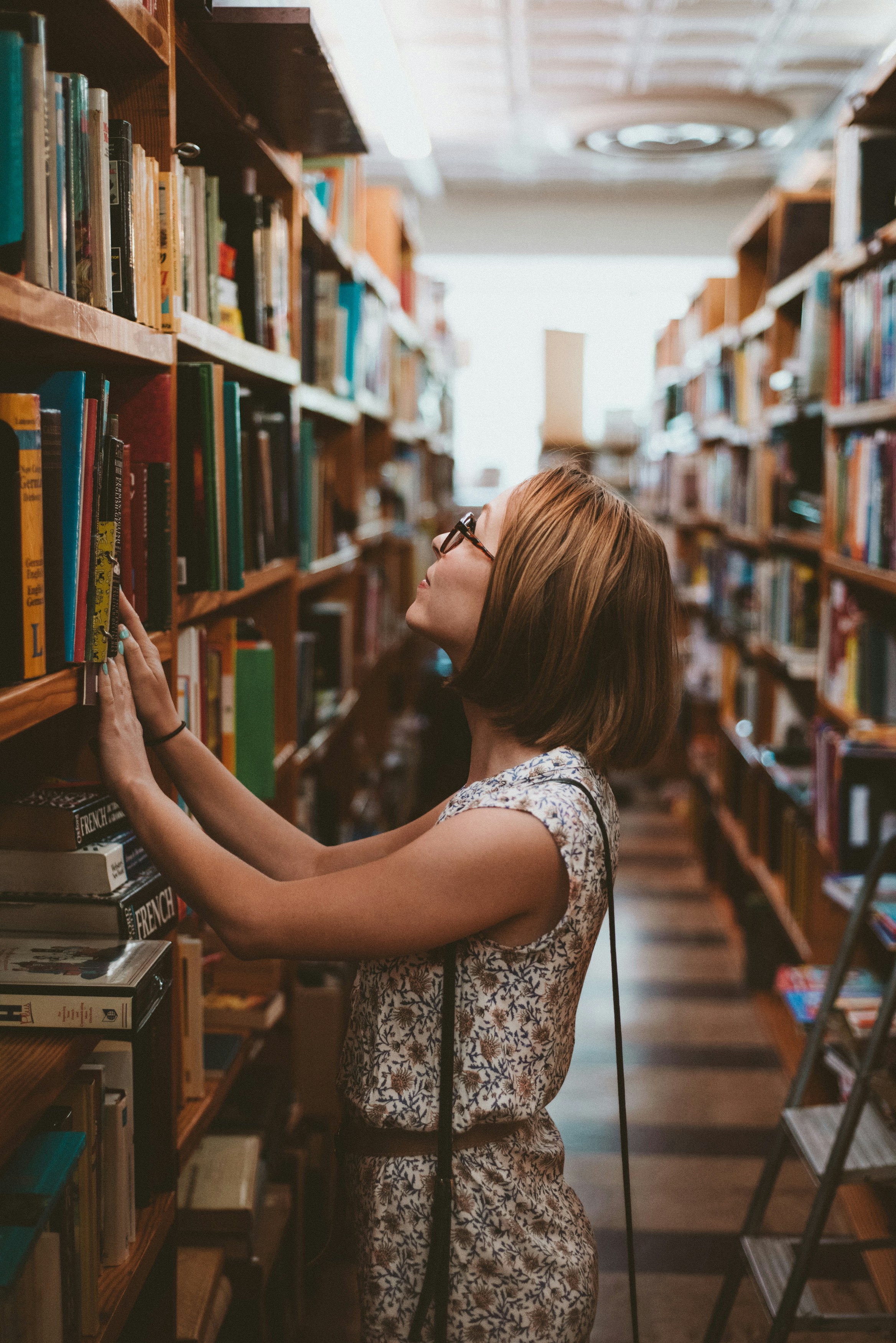 Une femme cherchant un livre dans une bibliothèque | Source : Unsplash