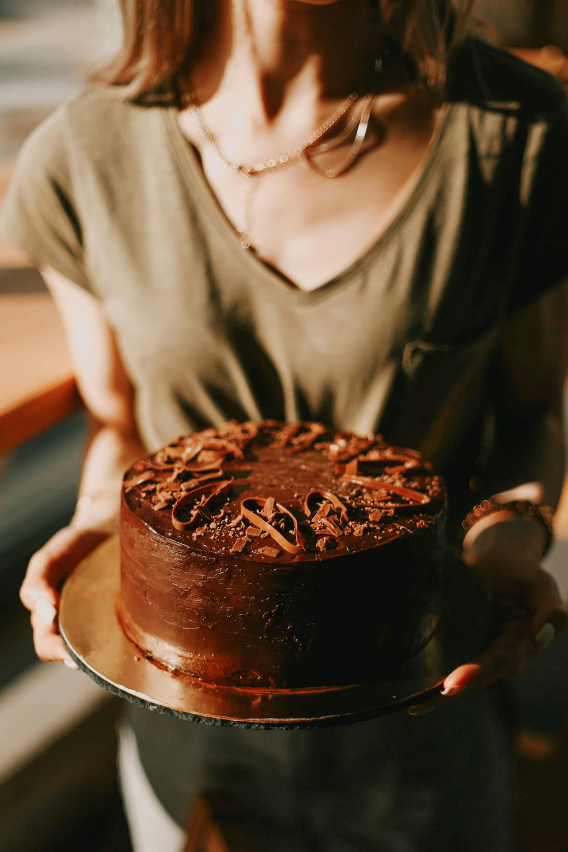 Gros plan d'une femme tenant un gâteau au chocolat | Source : Pexels