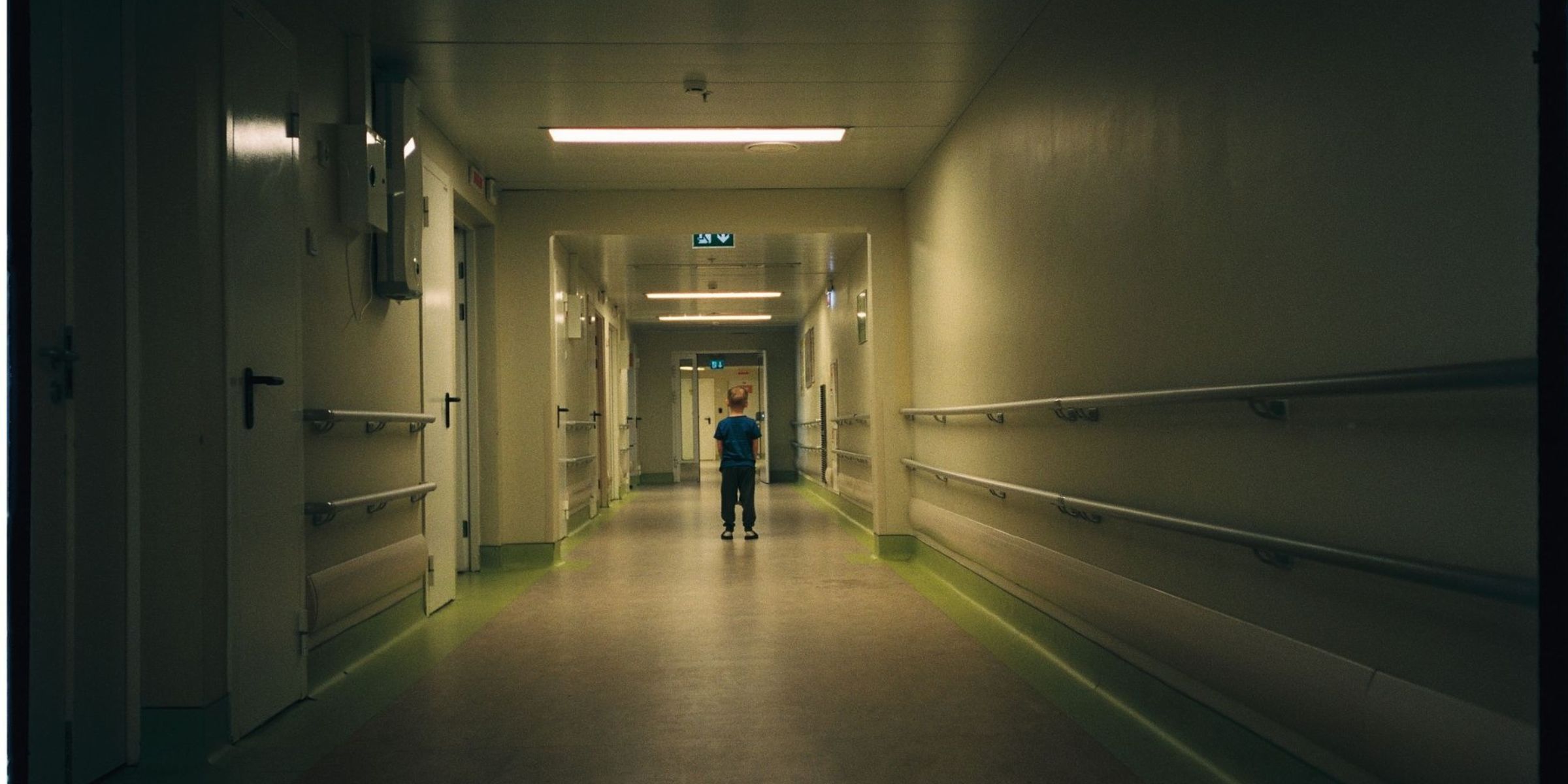 Un petit enfant tout seul dans un couloir d'hôpital à la lumière tamisée | Source : Pexels