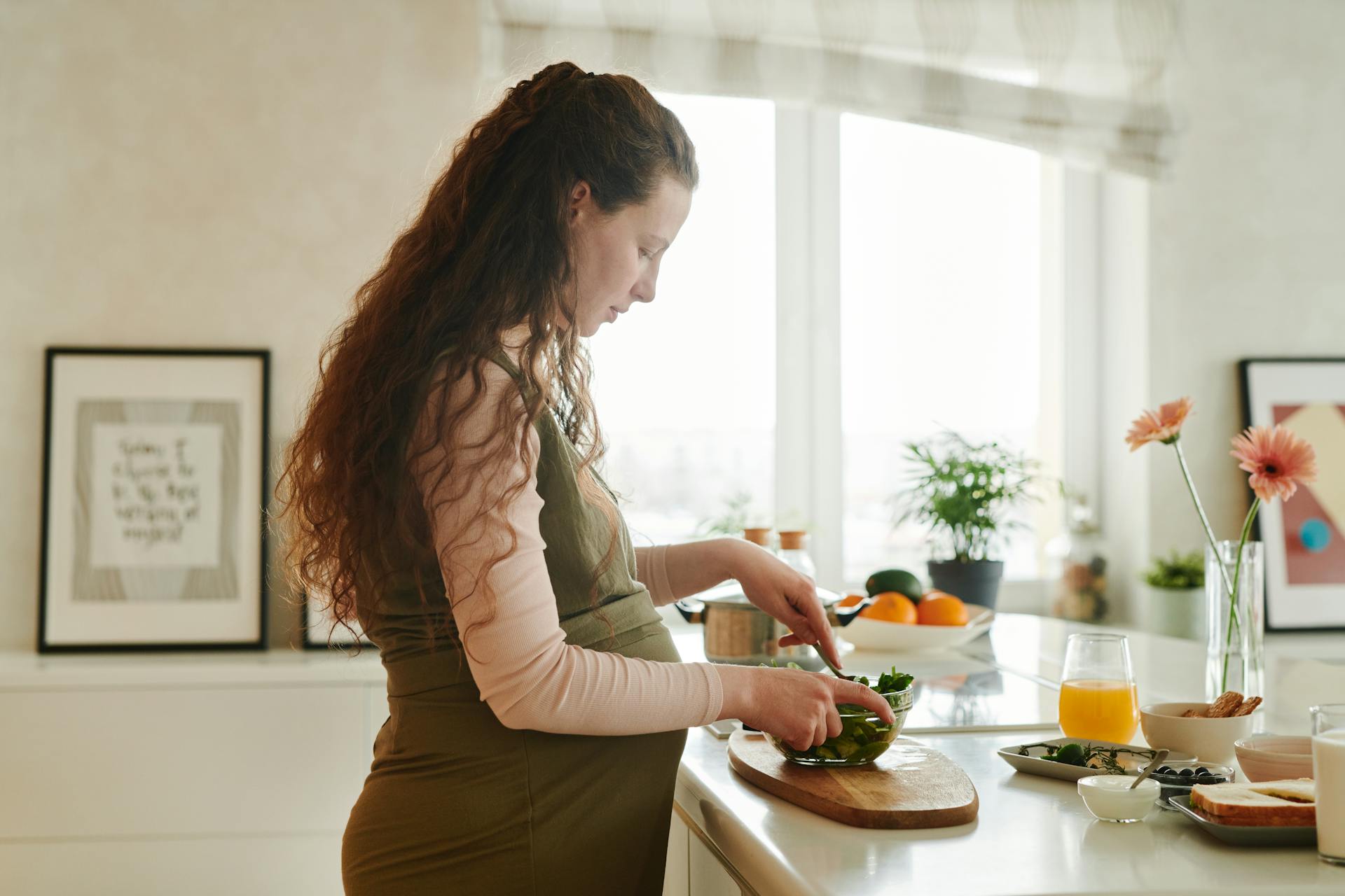 Une femme enceinte préparant des plats sur le comptoir de la cuisine | Source : Pexels