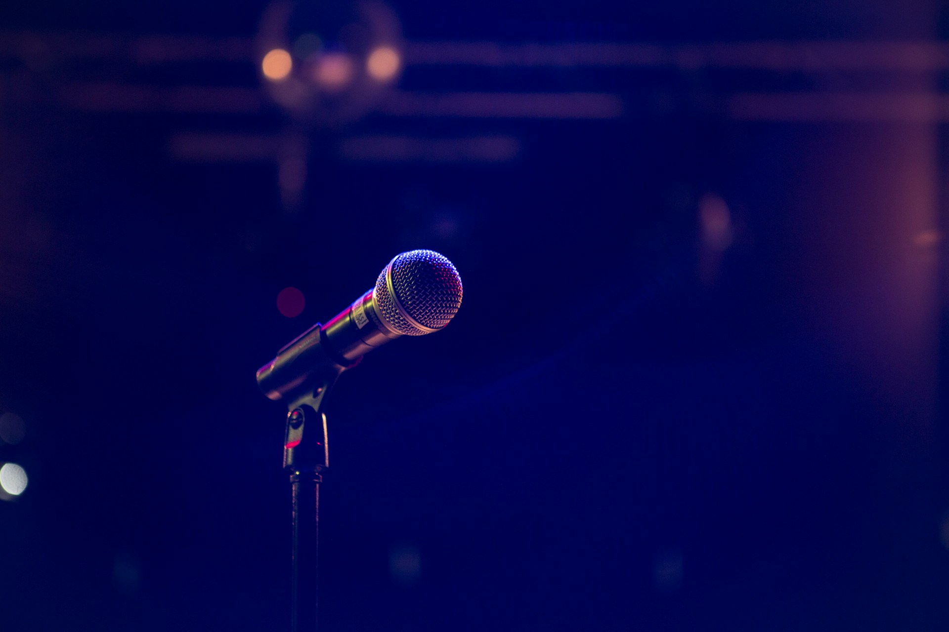 Un micro sur la scène baigné d'une douce lumière de studio | Source : Unsplash