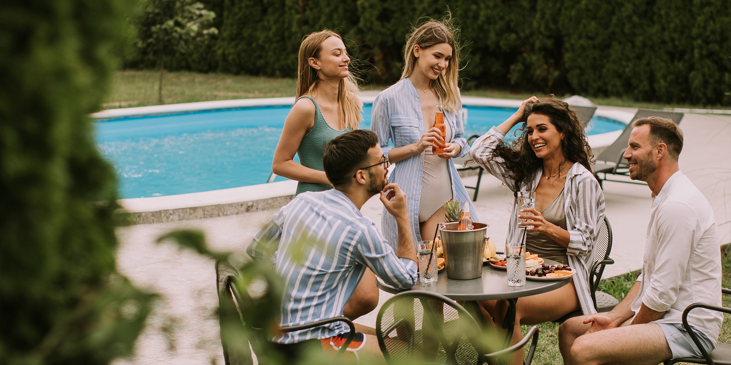 Des gens assis autour d'une piscine | Source : Shutterstock