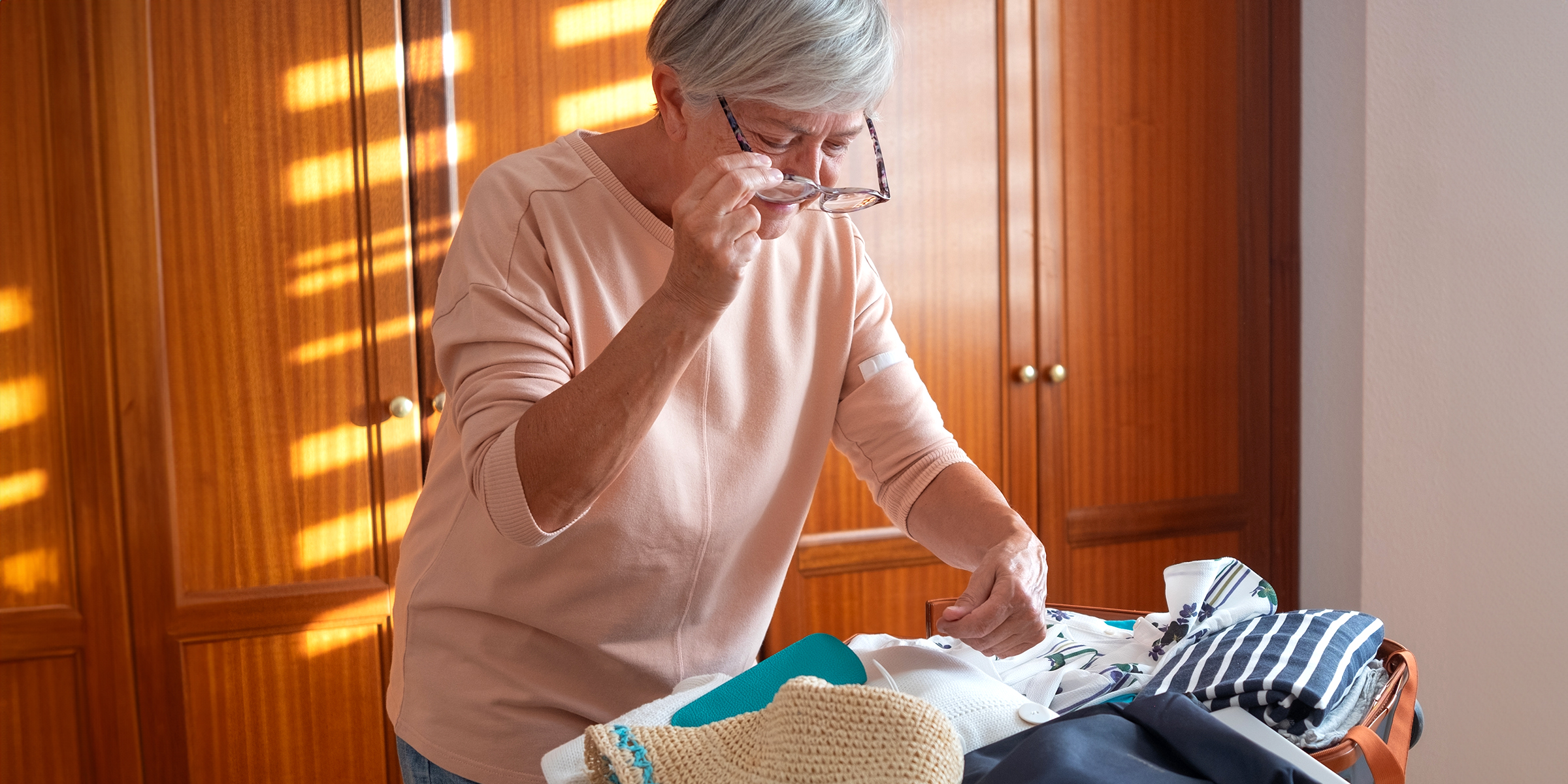 Une femme âgée qui range de vieux vêtements | Source : Shutterstock