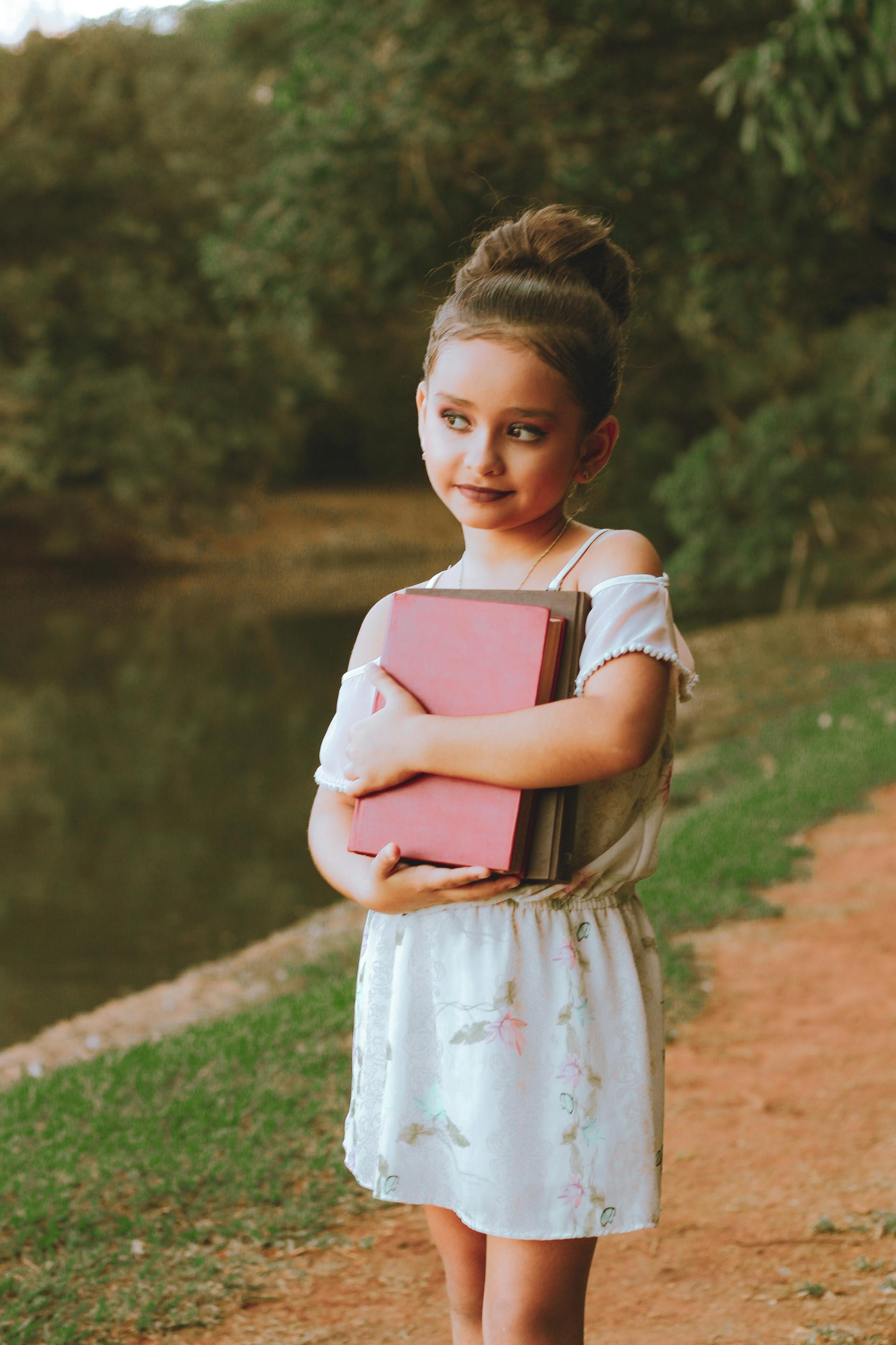 Une petite fille portant des livres | Source : Pexels