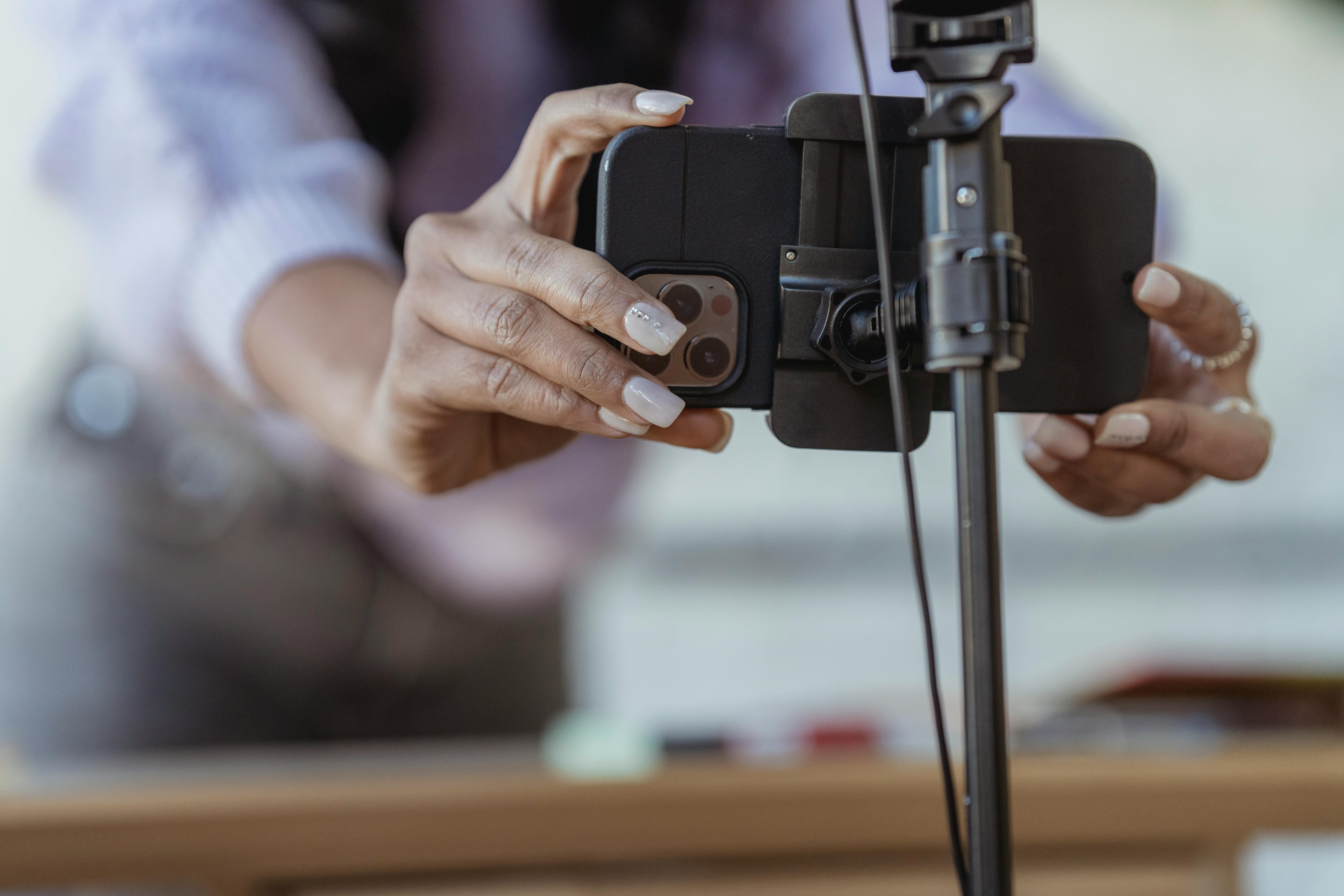 Une femme qui règle son téléphone sur un trépied | Source : Pexels