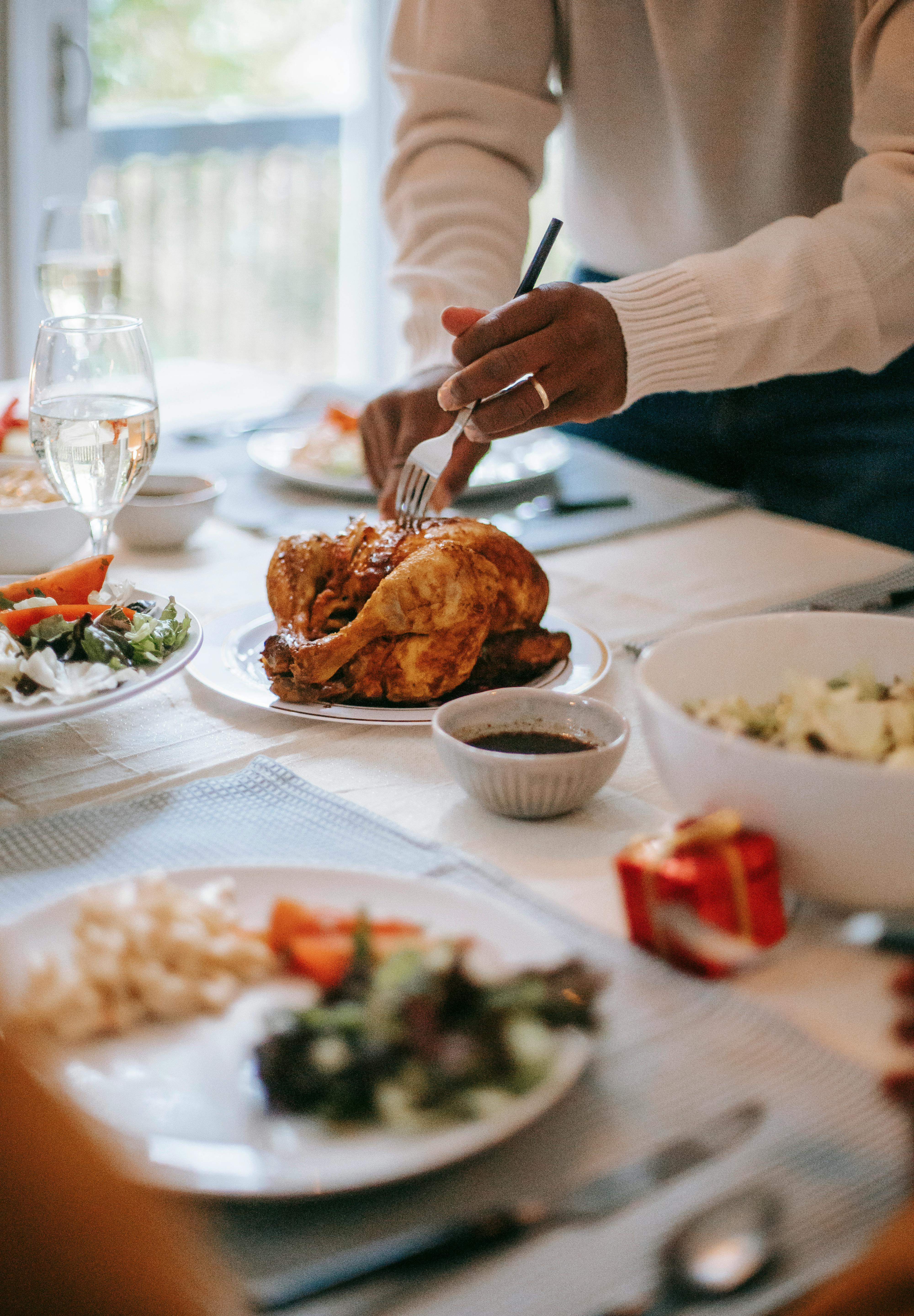 Une personne qui découpe du poulet | Source : Pexels