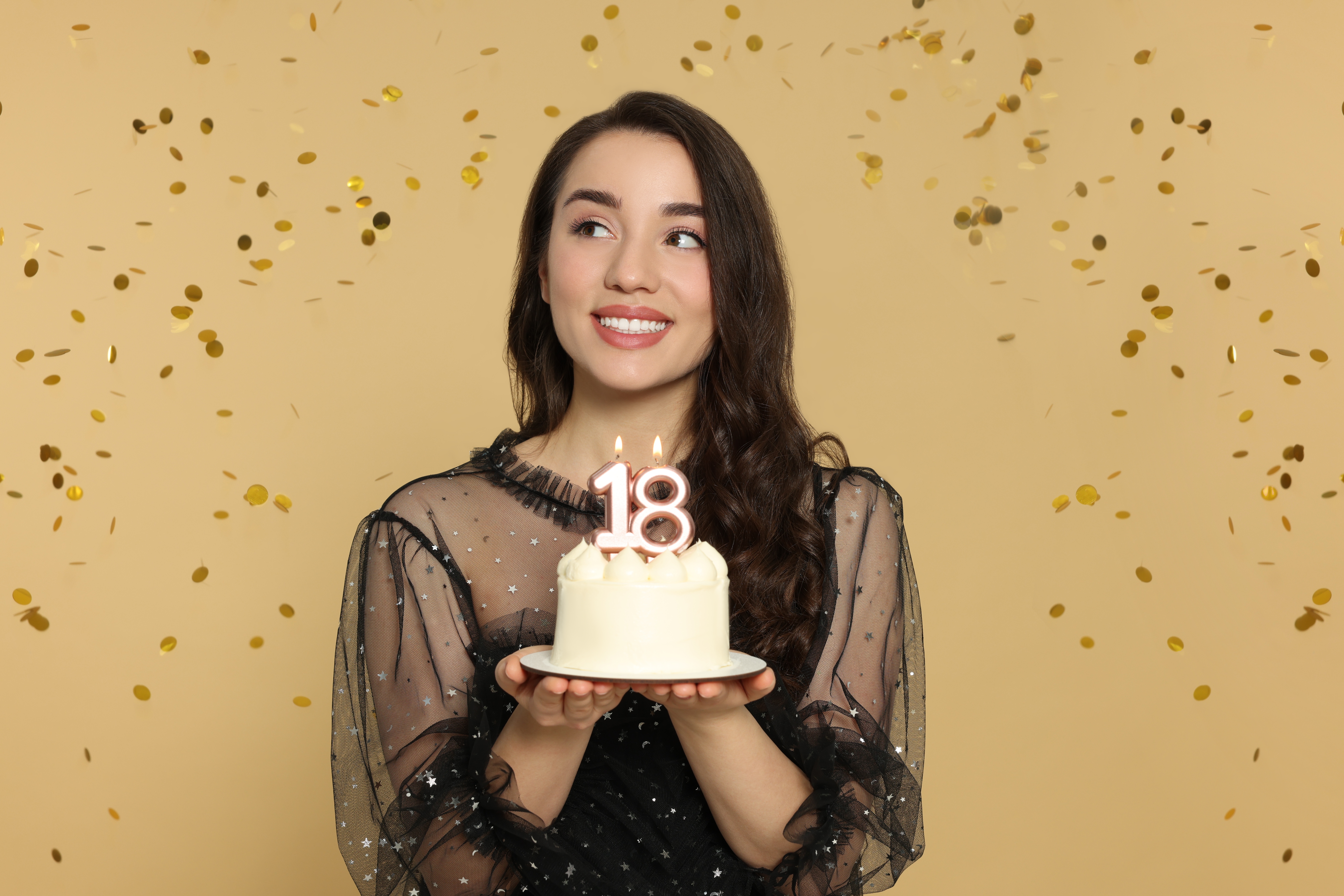 Une jeune femme tenant son gâteau d'anniversaire de 18 ans | Source : Shutterstock