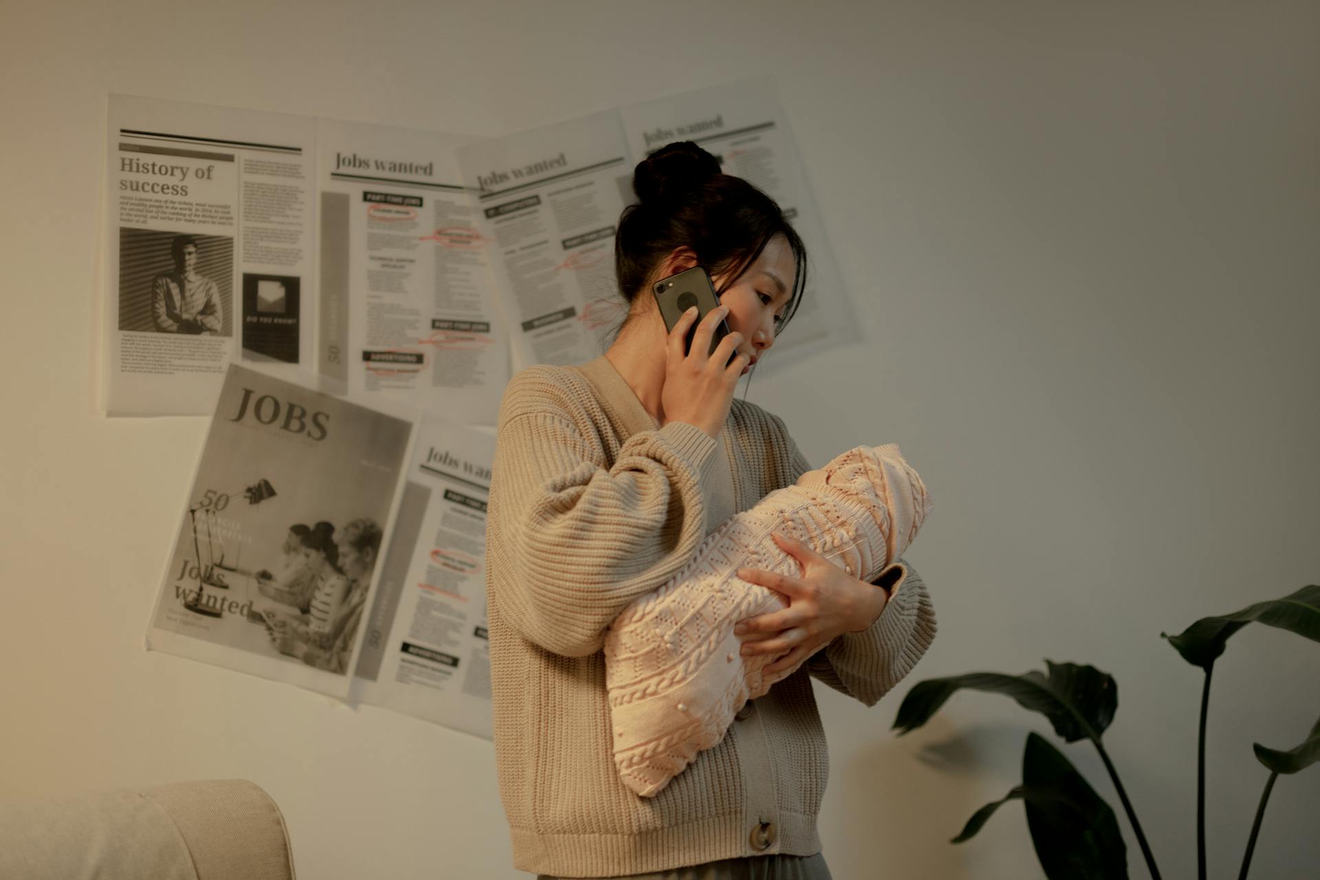 Une femme qui parle au téléphone tout en tenant son bébé | Source : Pexels