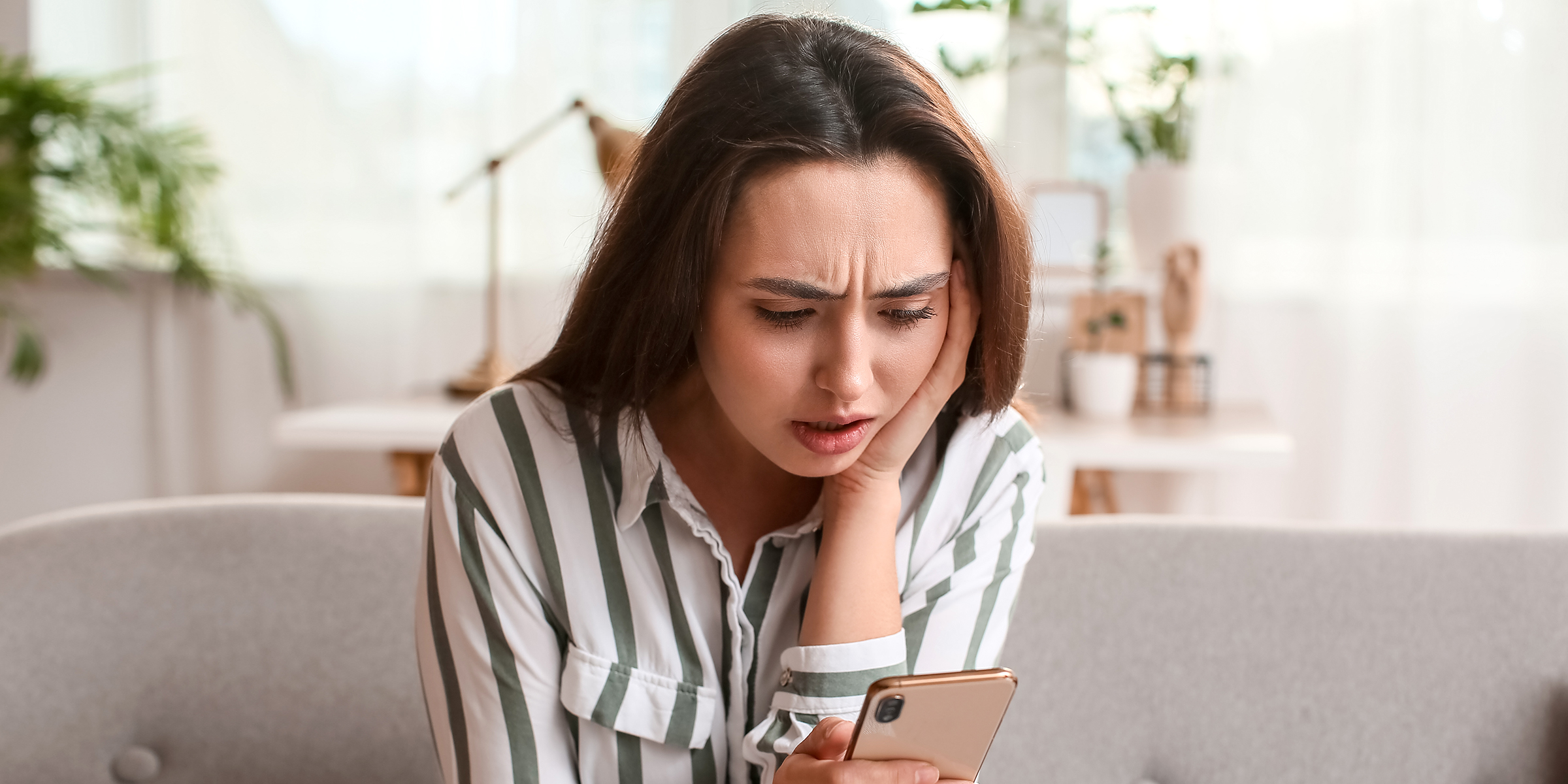 Une femme choquée lisant un texto sur son téléphone | Source : Shutterstock