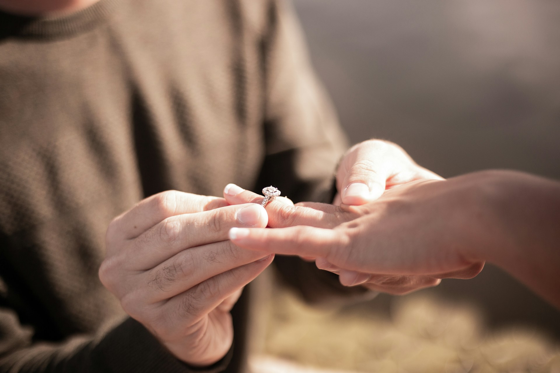 Gros plan recadré d'un homme glissant une bague au doigt d'une femme | Source : Unsplash