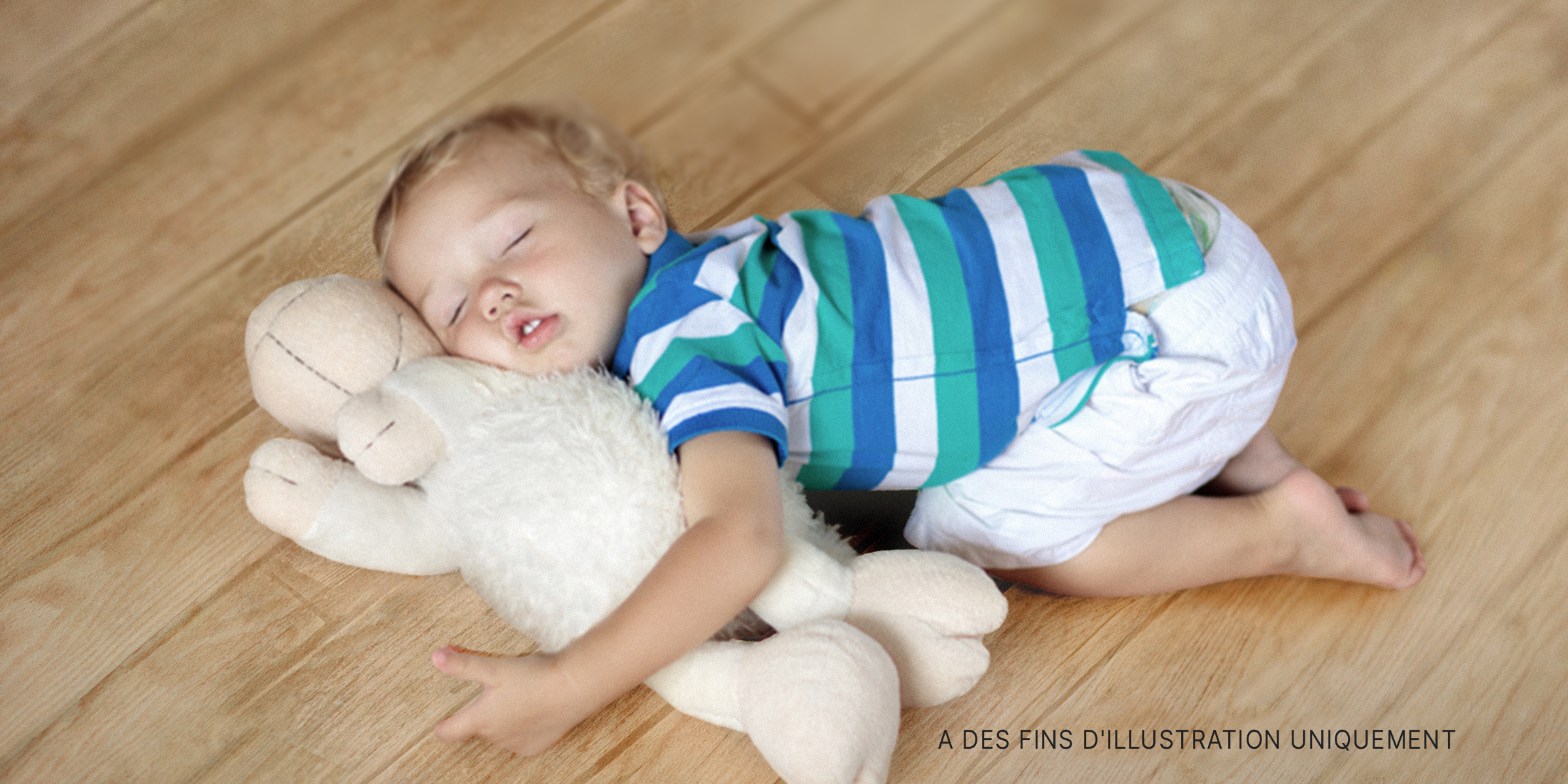 Un enfant sur le sol avec une peluche | Source : Shutterstock