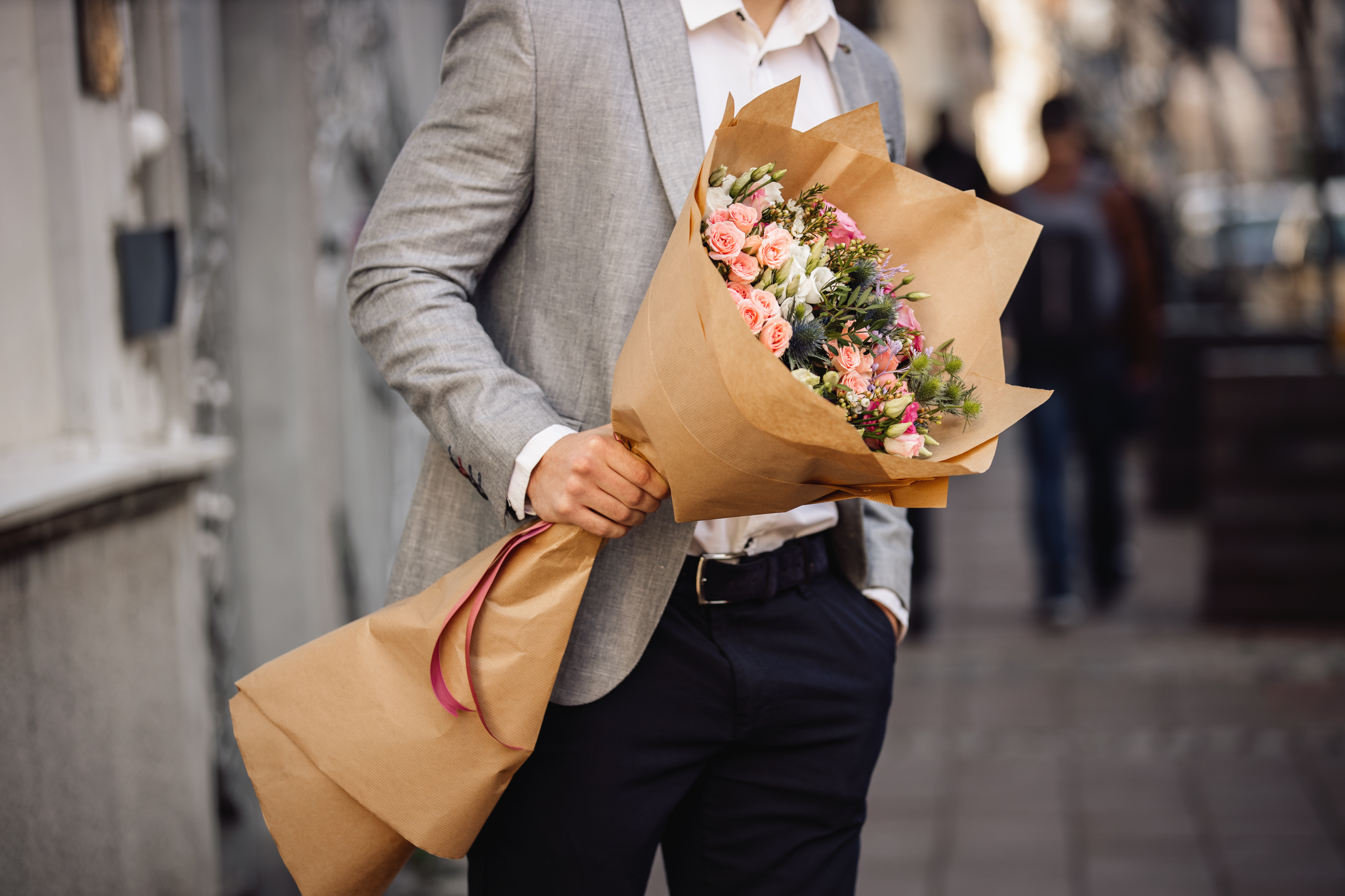 Jeune homme tenant un beau bouquet de fleurs fraîches | Source : Getty Images