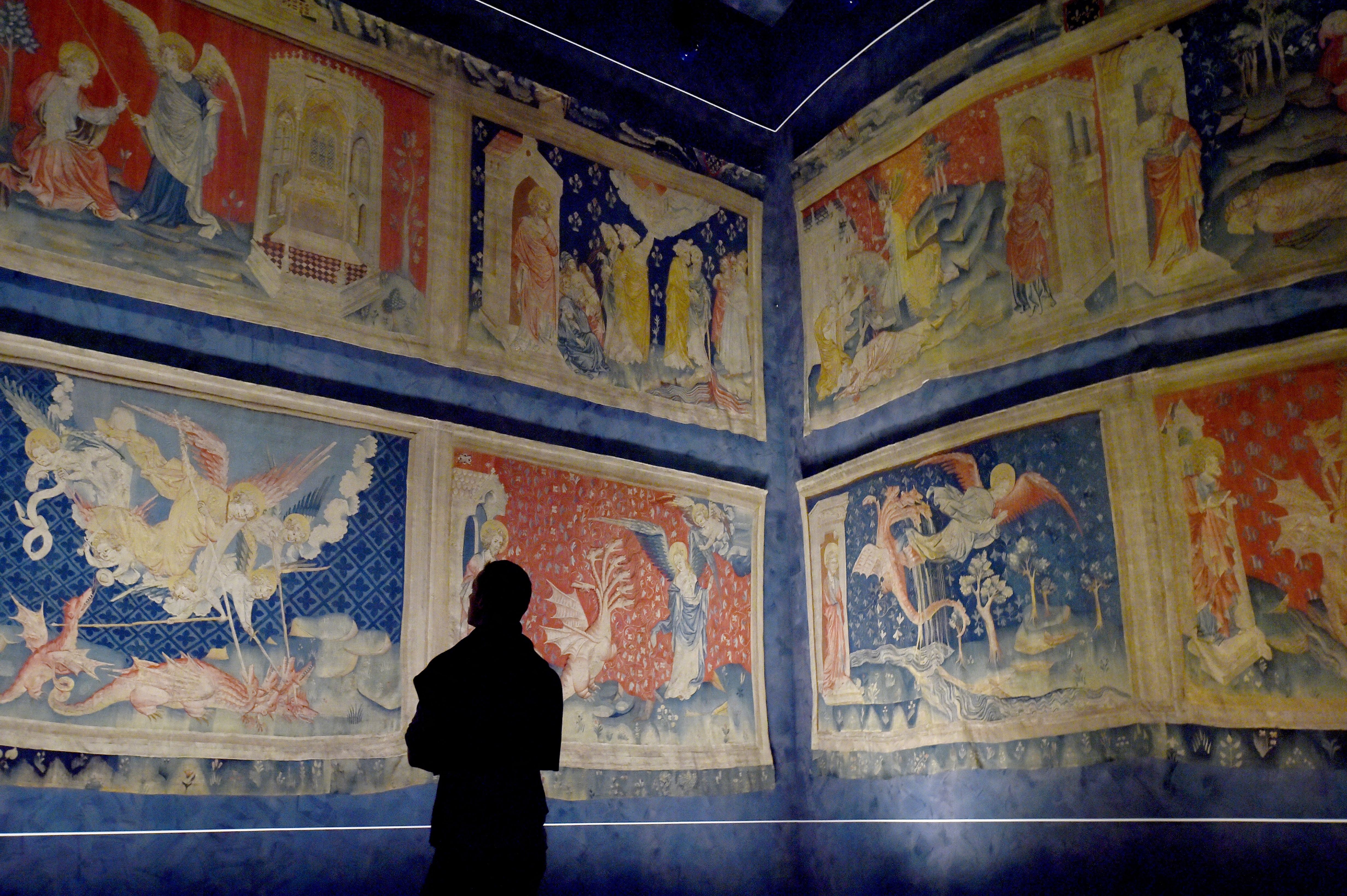 Un visiteur regarde la "Tapisserie de l'Apocalypse" (1377 - 1382), le plus grand et le plus ancien ensemble de tapisseries médiévales au monde, au château d'Angers, dans l'ouest de la France, le 22 septembre 2016 I Source : Getty Images