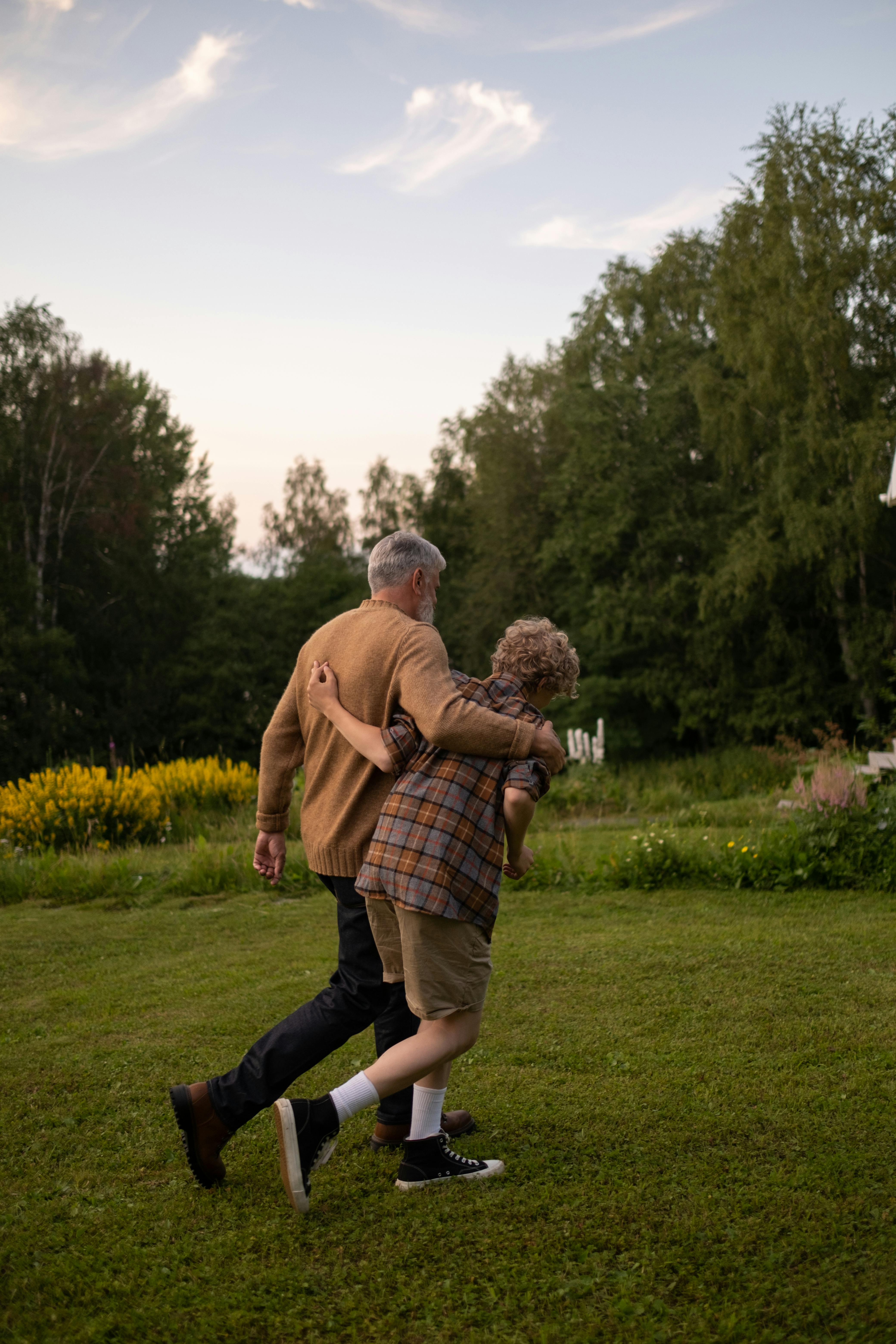 Un grand-père et son petit-fils se promenant dans un jardin | Source : Pexels