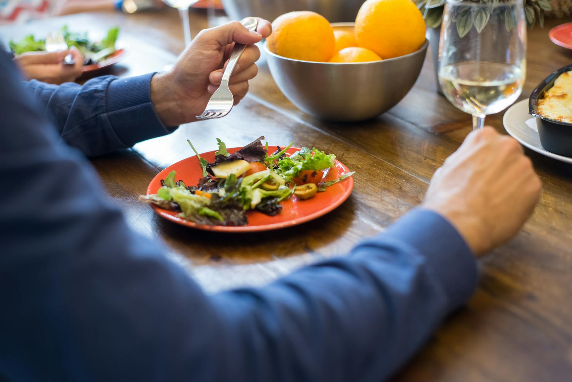 Une personne assise à une table et mangeant de la salade | Source : Pexels