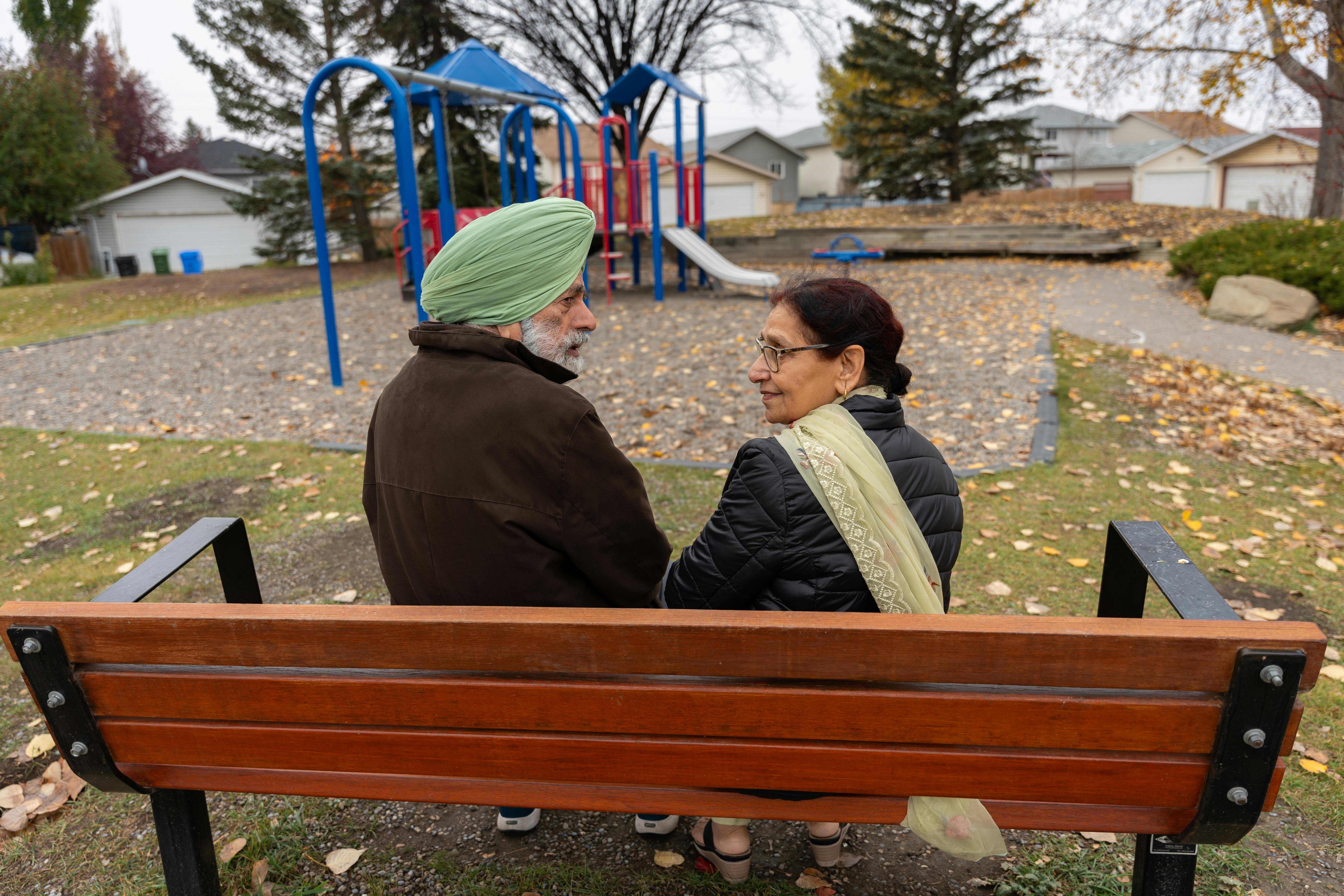 Un couple d'âge moyen regarde derrière son dos alors qu'il est assis sur un banc | Source : Pexels