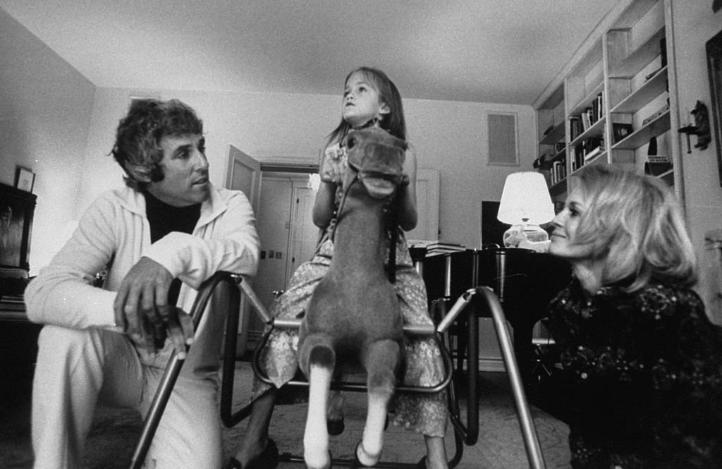 Le compositeur Burt Bacharach Jr. (à gauche) et son épouse actrice Angie Dickinson regardent leur fille monter un cheval à bascule. | Source : Getty Images