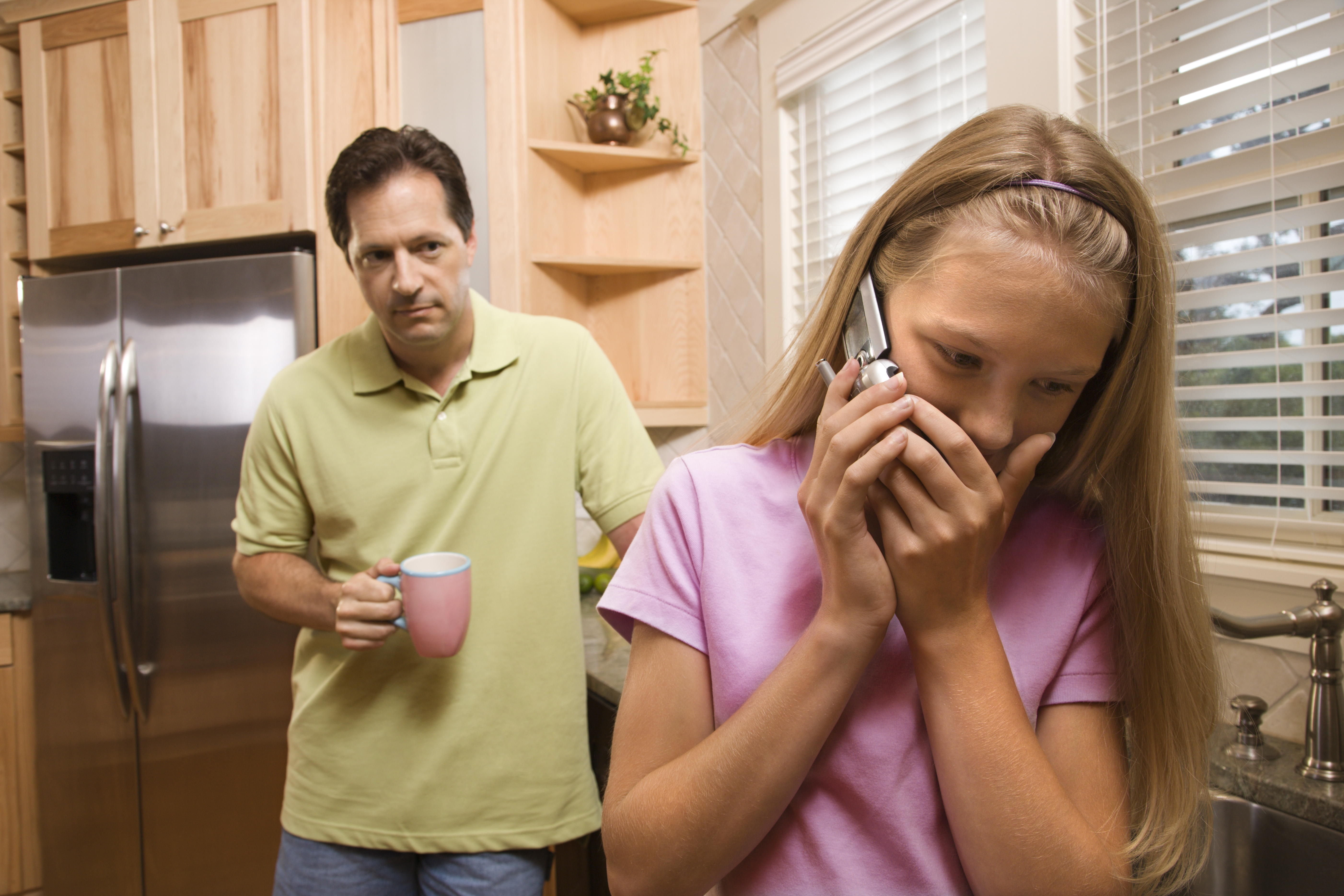 Un homme qui regarde une jeune fille parler au téléphone | Source : Shutterstock