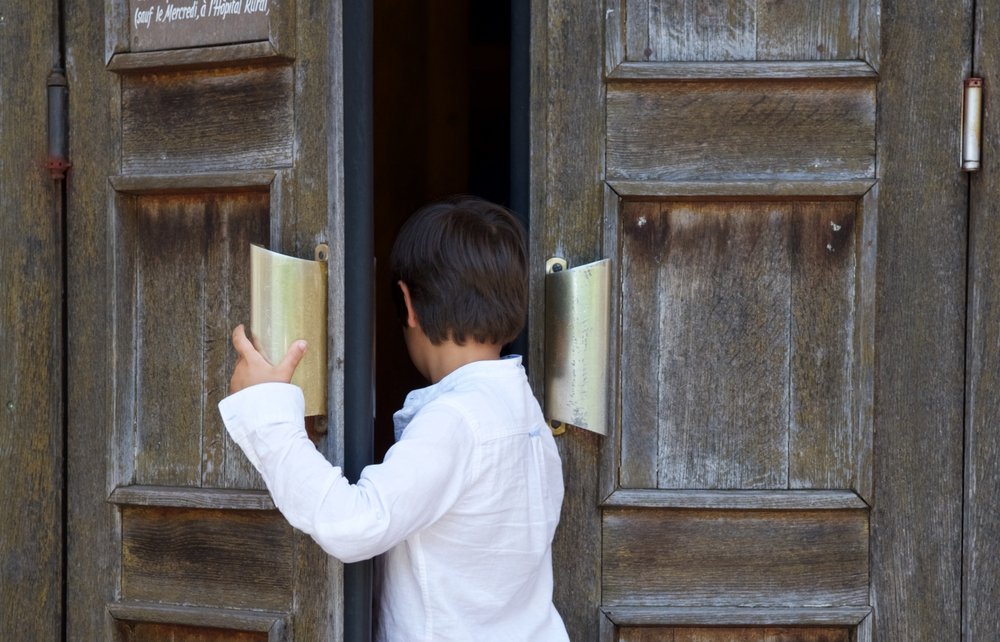 Un petit garçon entrant dans une église | Photo : Shutterstock