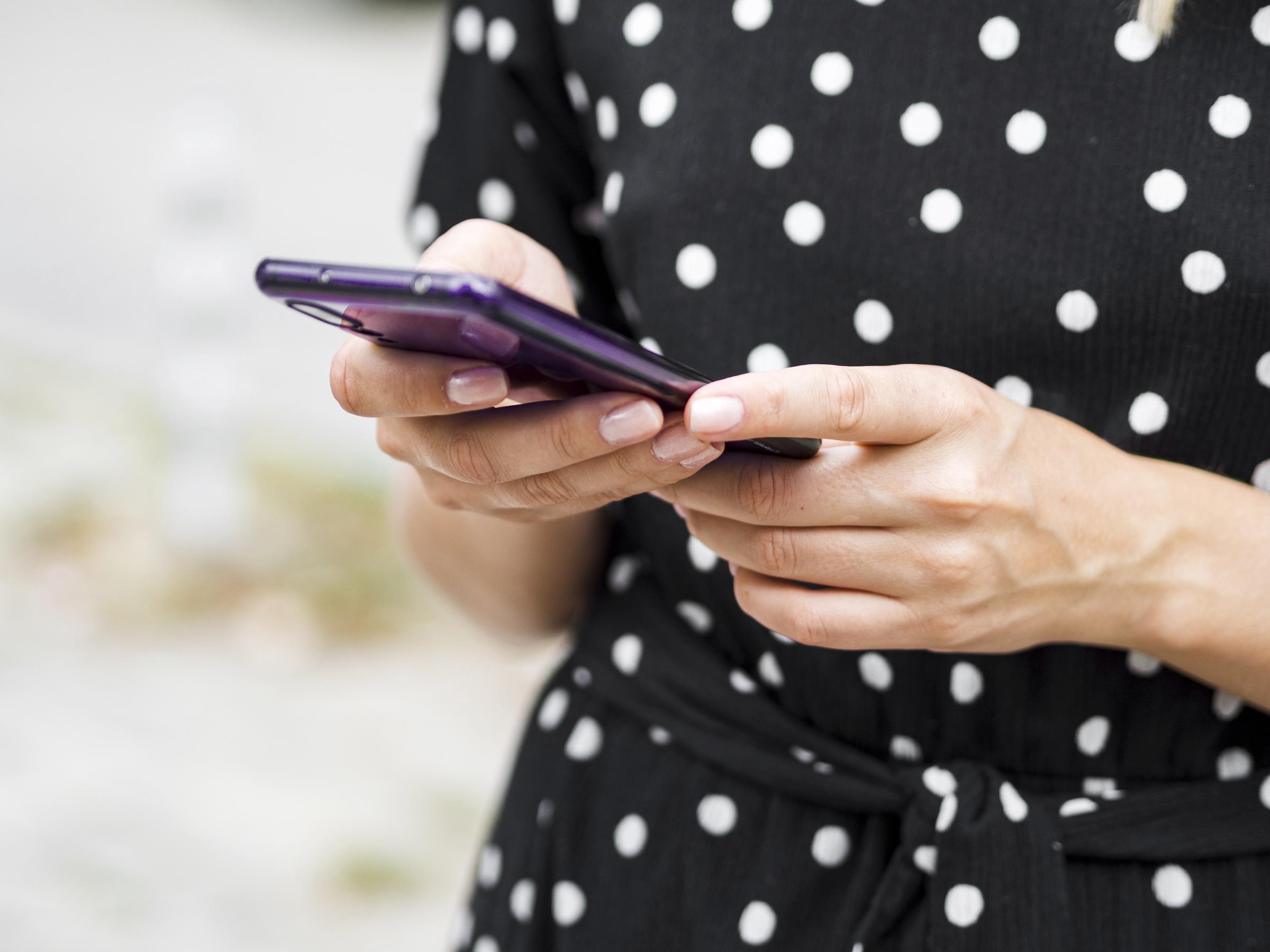 Une femme tapant un message sur son téléphone | Source : Freepik