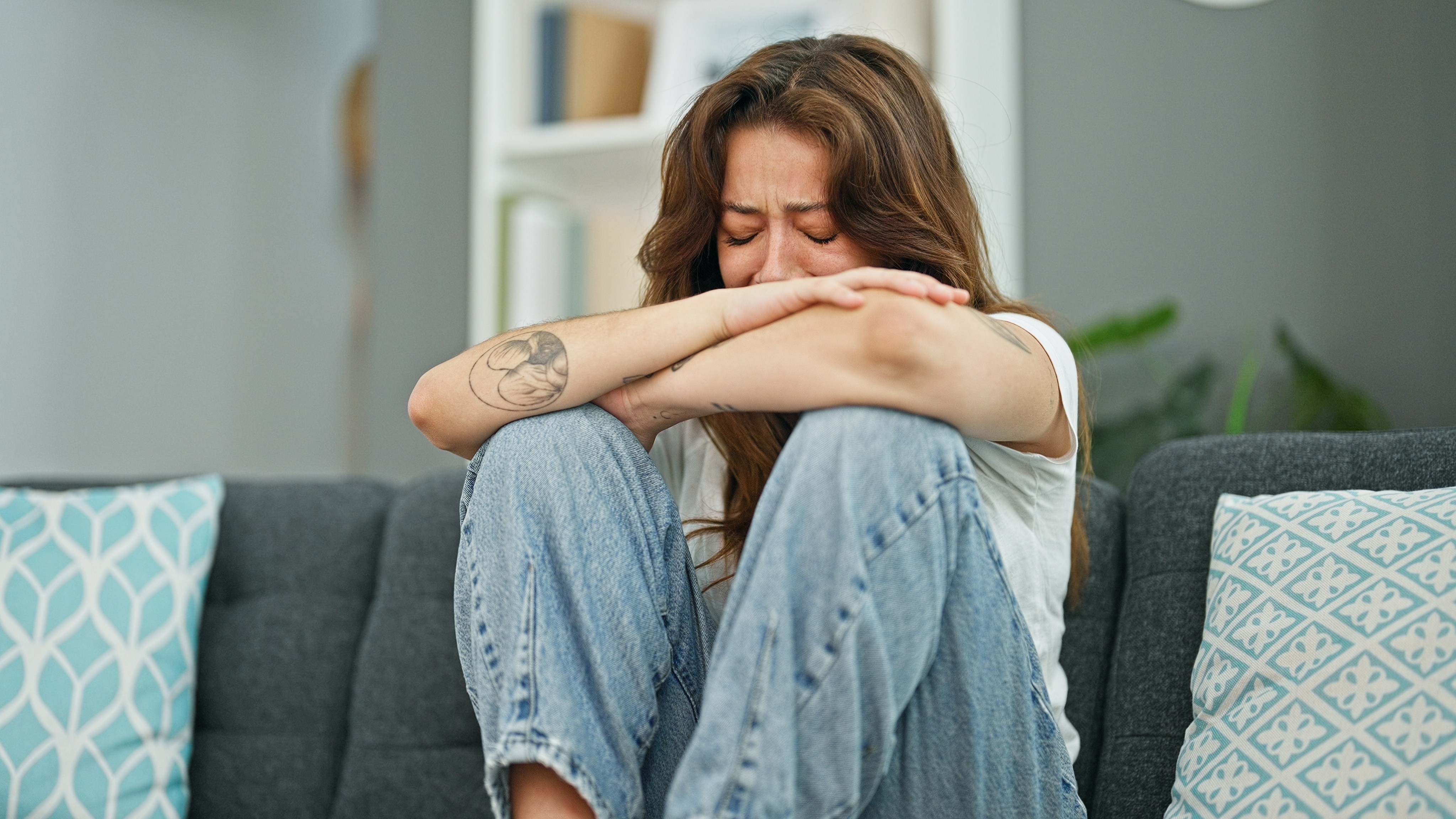 Femme en pleurs sur le canapé | Shutterstock