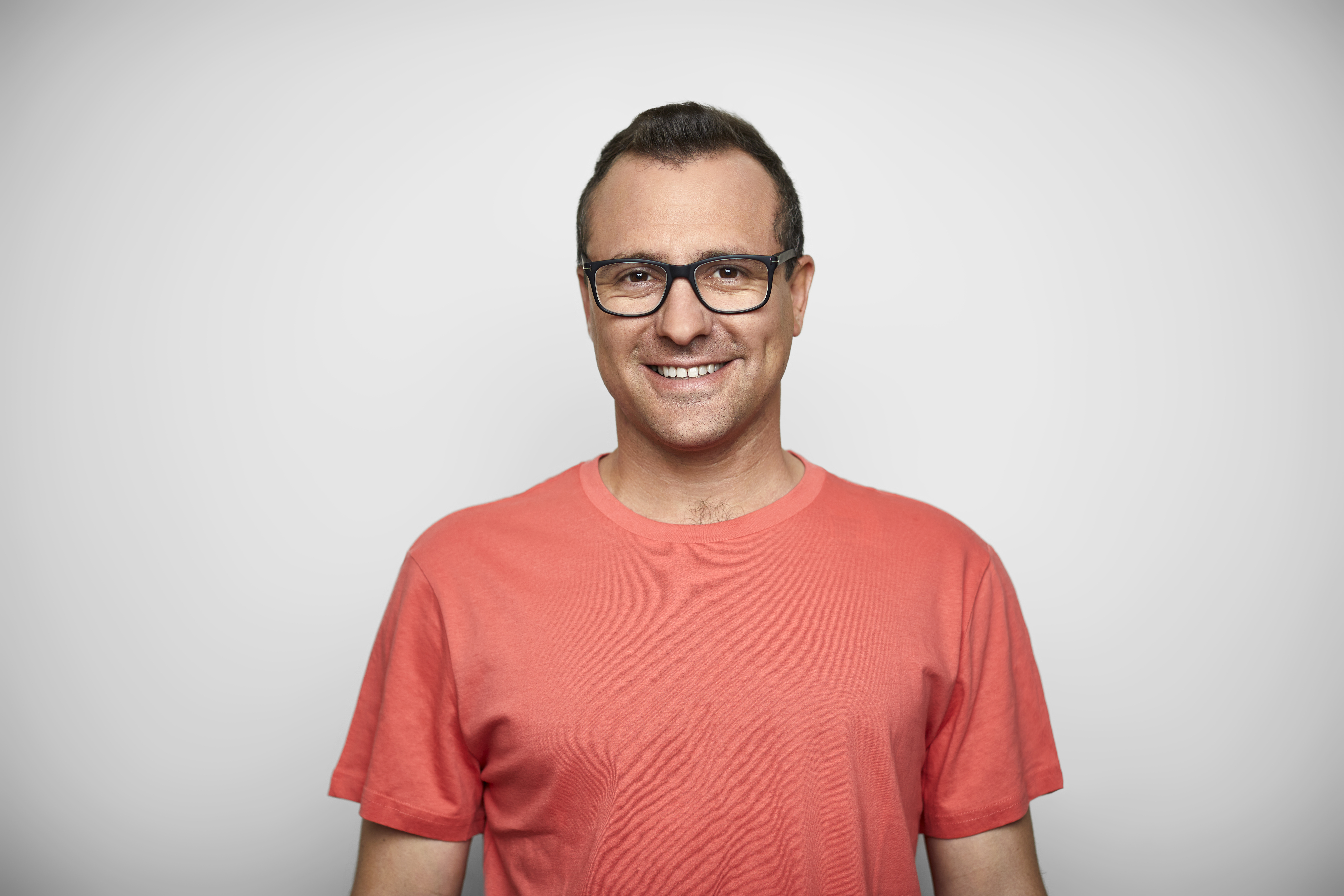 Un homme avec un t-shirt et des lunettes | Source : Getty Images