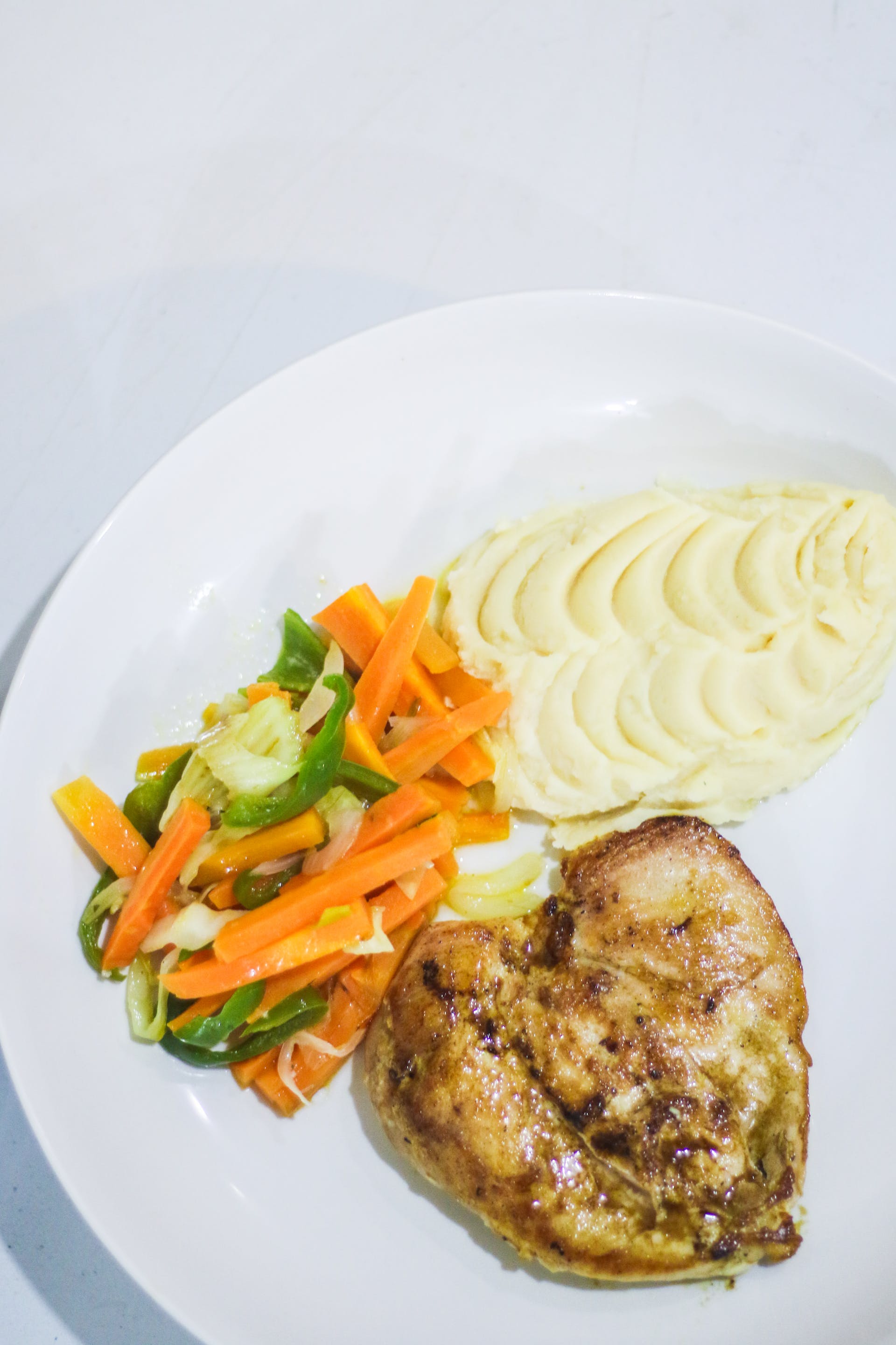 Un plato de pechuga de pollo, verduras y puré de patatas | Fuente: Pexels
