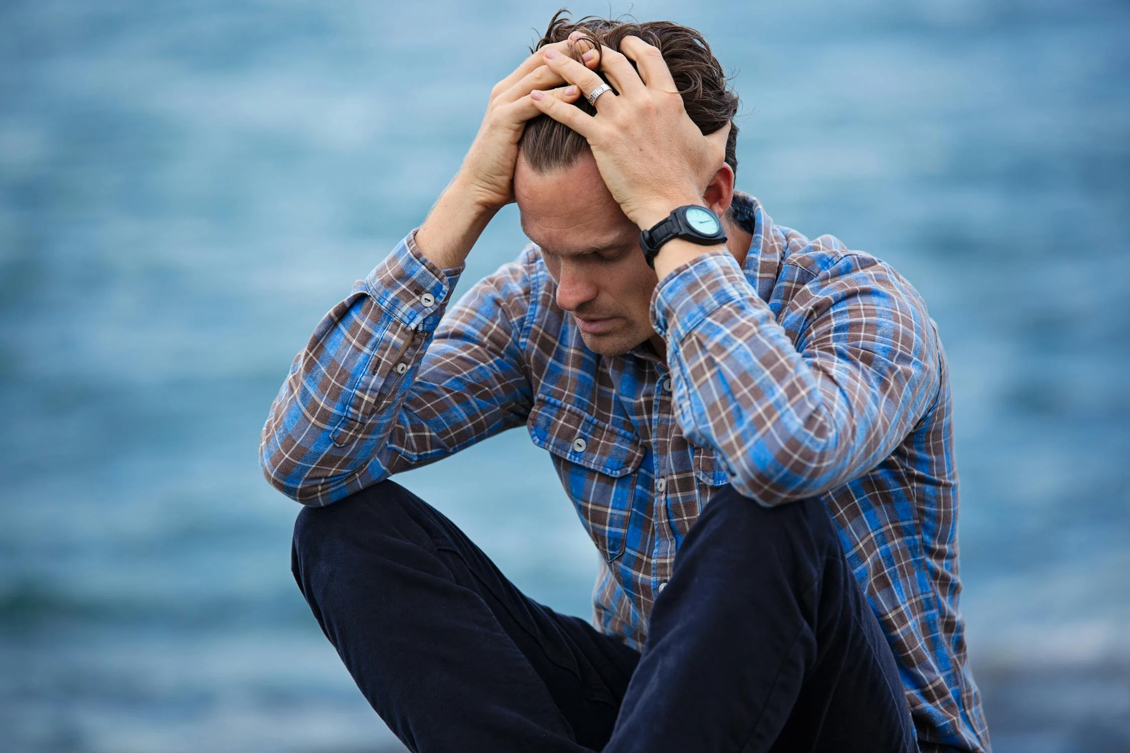 Un homme triste assis au bord de la mer | Source : Pexels