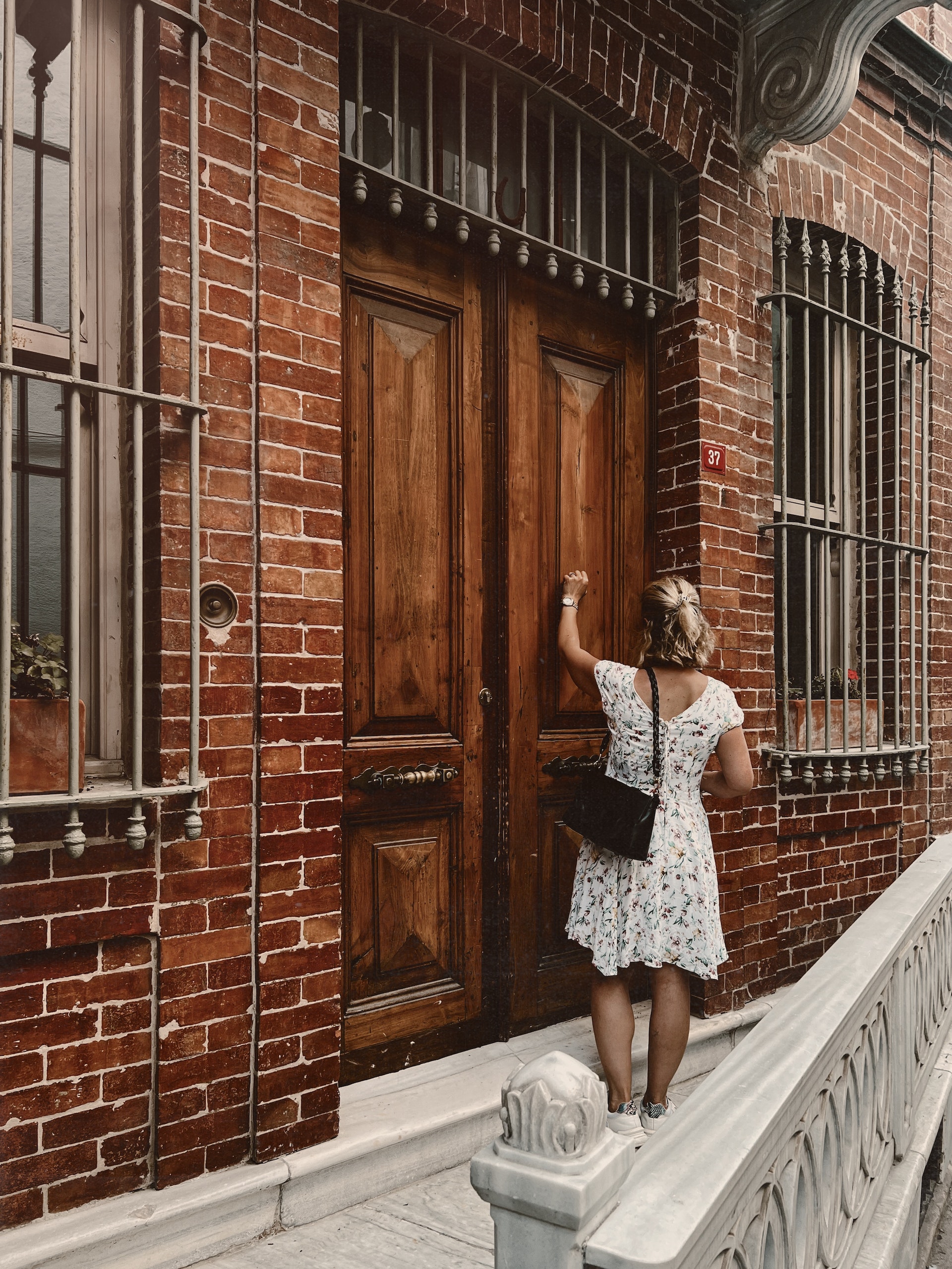 Une femme frappe à une porte en bois | Source : Pexels
